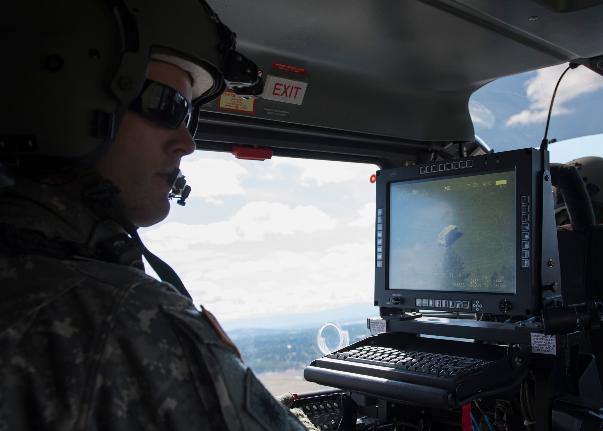 Sgt. Darrell Russell, C Company, 1st Battalion, 112th Airborne Regiment Lakota crew chief, spots a disabled truck using the on-board camera system June 14, 2017, north of Fairchild Air Force Base, Washington. The Lakota is equipped with a nose mounted camera system that gives the light aircraft the ability to spot and lock onto targets from long distances.
(U.S. Air Force photo / Airman 1st Class Ryan Lackey)