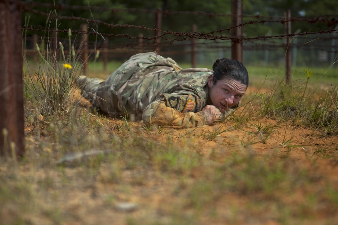 Army Sgt. Erin Hodge low-crawls under barbed wire during the 2017 Army Reserve Best Warrior Competition at Fort Bragg, N.C., June 13, 2017. Hodge is a preventive medicine specialist assigned to the 7th Mission Support Command. Army photo by Spc. Milcah Villaronga