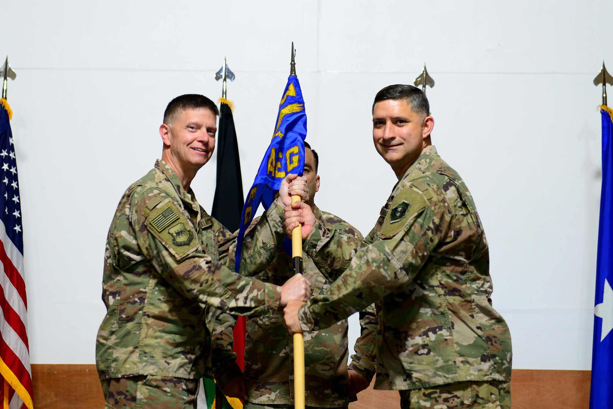 U.S. Air Force Brig. Gen. Kyle W. Robinson(left), 332nd Air Expeditionary Wing commander, passes the guidon to Col. John F. Gonzales at the 407th Air Expeditionary Group change of command ceremony on June 17, 2017 in Southwest Asia. The passing of the guidon is an age old tradition representing a formal transfer of authority and responsibility from an outgoing commander to an incoming one. (U.S. Air Force Tech Sgt. Andy M. Kin)