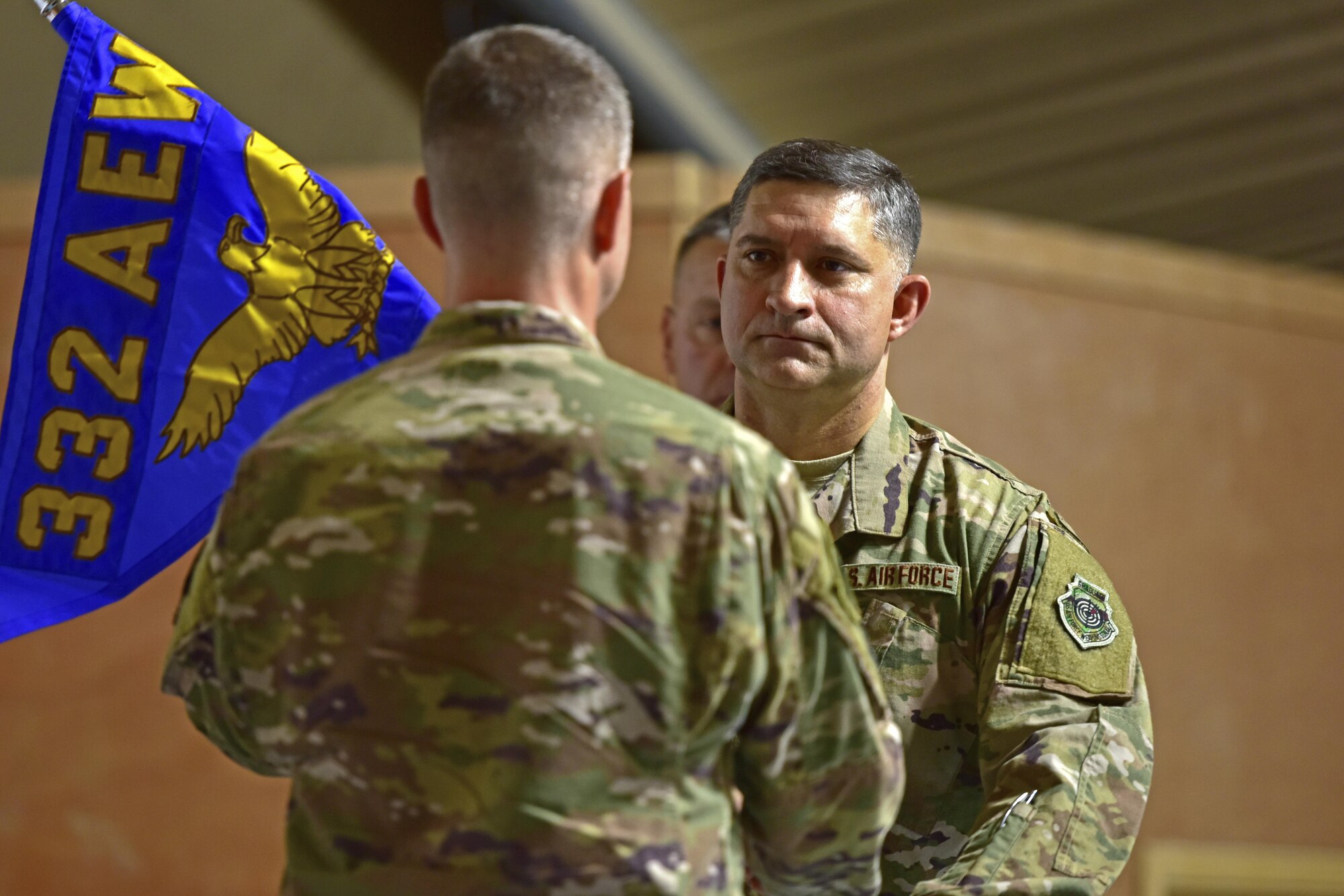 Brig. Gen Kyle Robinson, 332d Air Expeditionary Wing commander, passes a gudion to Col. John Gonzales, as Gonzales assumes command of the 407th Air Expeditionary Group June 17, 2017, in Southwest Asia. Prior to inheriting the 407th AEG, Gonzales was the deputy chief of the Middle East Directorate Joint Staff J5 Iran, Iraq, Syria Division. (U.S. Air Force photo by Senior Airman Ramon A. Adelan)