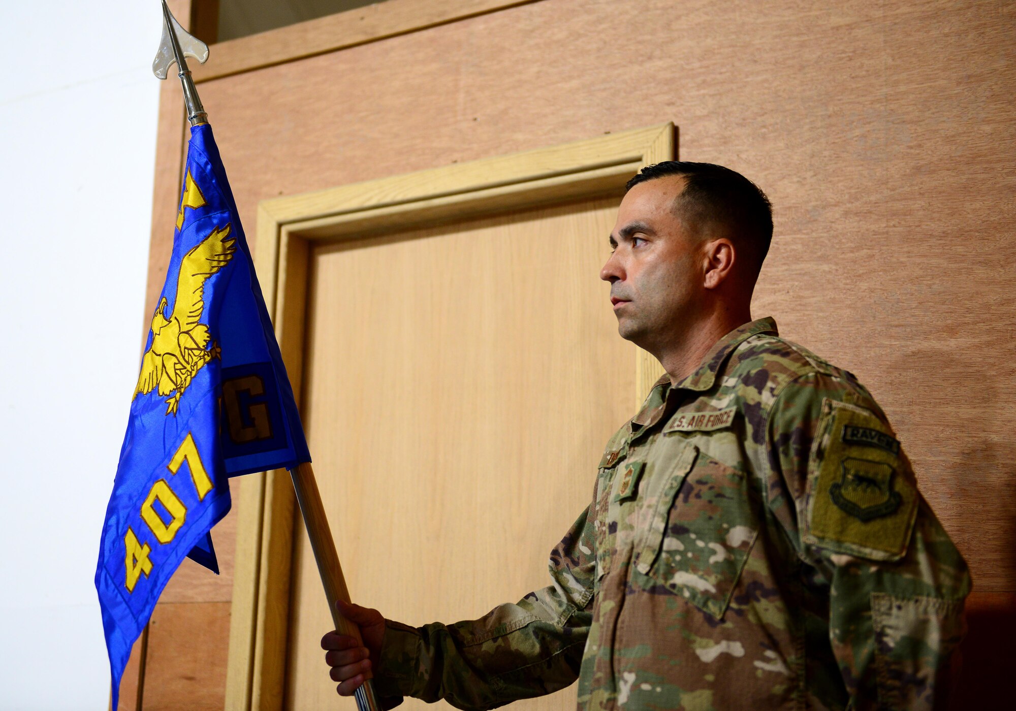 U.S. Air Force Chief Master Sgt. Joshua Drake, 407th Air Expeditionary Group superintendent, stands at parade rest with the guidon during the 407th AEG change of command ceremony on June 17, 2017 in Southwest Asia. The passing of the guidon is an age old tradition representing a formal transfer of authority and responsibility from an outgoing commander to an incoming one. (U.S. Air Force Tech Sgt. Andy M. Kin)