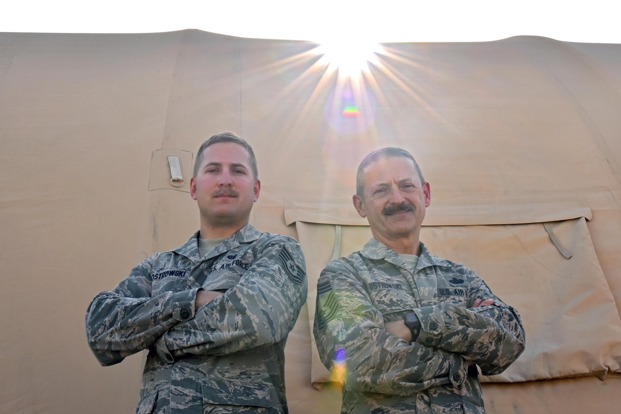 Tech. Sgt. Tyler Ostrowski, left, and Chief Master Sgt. Ted Ostrowski, Sr., stand outside of a tent at an undisclosed location in Southwest Asia, June 16, 2017. Ted and Tyler will spend Father's Day deployed with the 380th Air Expeditionary Wing in support of Combined Joint Task Force - Operation Inherent Resolve. (U.S. Air Force photo by Staff Sgt. Marjorie A. Bowlden)