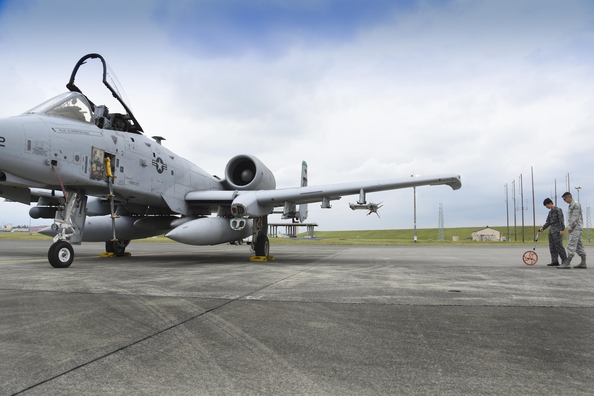 Japan Air Self-Defense Force Tech. Sgt. Hironobu Kakuta, Flight Information Squadron air operation, measures distances between aircraft to ensure there is adequate wingtip clearance during the Bilateral Exchange Program at Yokota Air Base, Japan, June 7, 2017. A total of 14 Japan Air Self-Defense Force members from a variety of career fields participated in the program. They were provided with hands-on experience working in their related fields to see how Yokota conducts its mission. (U.S. Air Force photo by Machiko Arita)