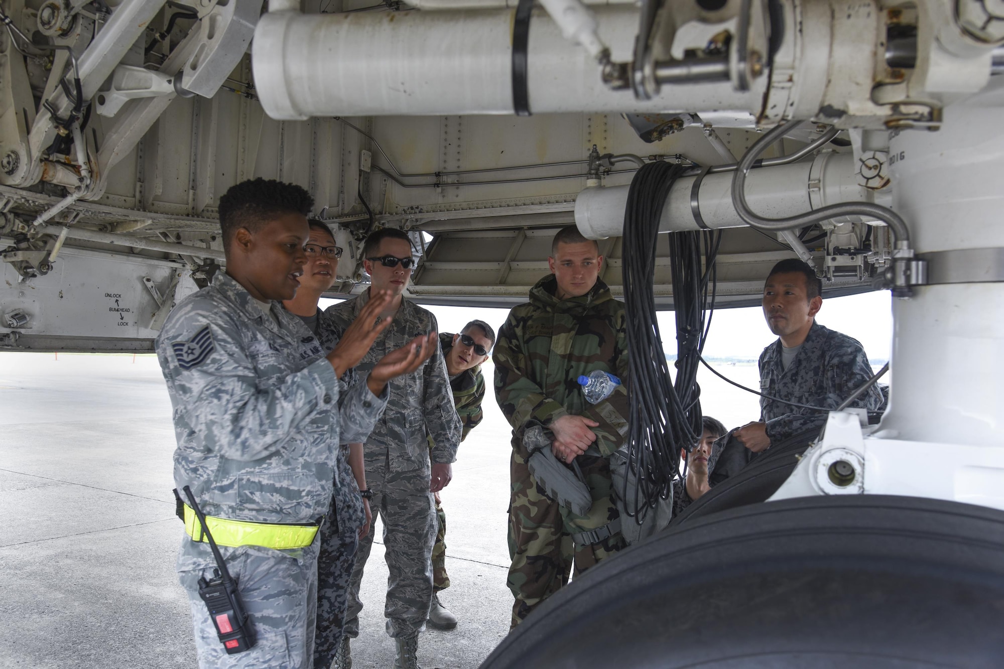 U.S. Air Force Tech. Sgt. Brittany Kemp, 730th Air Mobility Squadron crew chief, explains the C-5M Super Galaxy tires to participants during the Bilateral Exchange Program at Yokota Air Base, Japan, June 8, 2017. A total of 14 Japan Air Self-Defense Force members from a variety of career fields participated in the program. They were provided with hands-on experience working in their related fields to see how Yokota conducts its mission. (U.S. Air Force photo by Machiko Arita)
