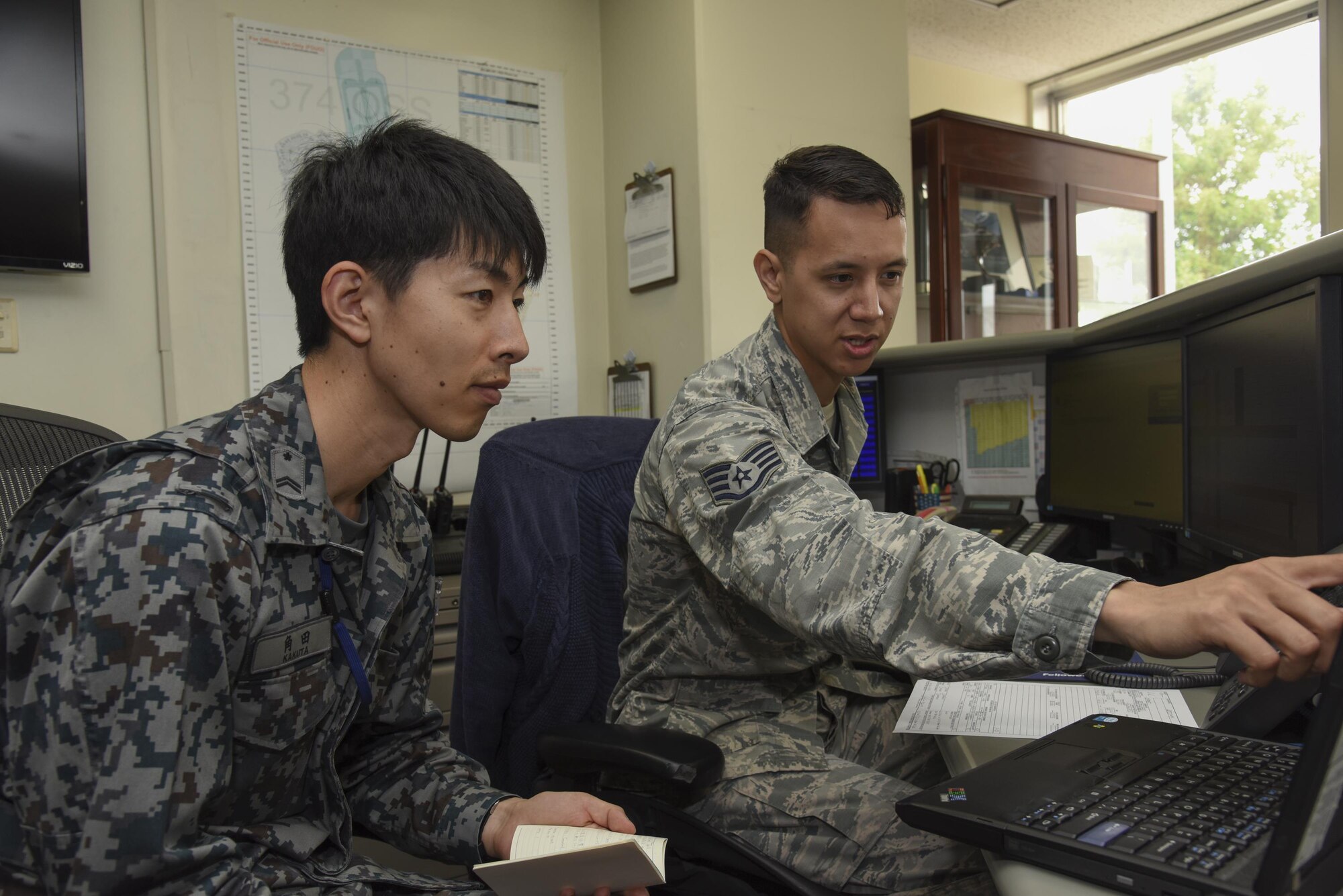 U.S. Air Force Staff Sgt. Michael Ober, 374th Operation Support Squadron NCO in charge of
airfield management training, explains his unit's flight planning to Japan Air Self-Defense Force Tech. Sgt. Hironobu Kakuta, Flight Information Squadron air operation, during the Bilateral Exchange Program at Yokota Air Base, Japan, June 7, 2017. A total of 14 Japan Air Self-Defense Force members from a variety of career fields participated in the program. They were
provided with hands-on experience working in their related fields to see how Yokota conducts its mission. (U.S. Air Force photo by Machiko Arita)