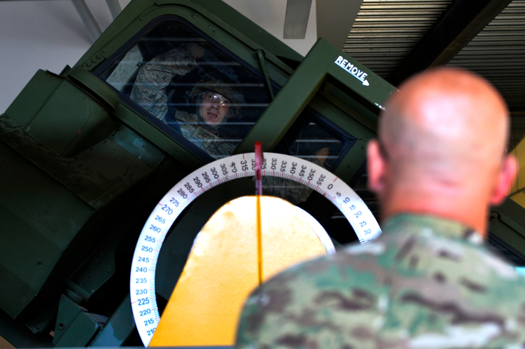 U.S. Air Force Master Sgt. Richard Koch, 7th Weather Squadron non-commissioned officer in charge of readiness, watches U.S. Air Force Staff Sgt. Dallas Rhodes, 7th WS unit deployment manager, undergo Humvee egress training on Lucius D. Clay Kaserne, Germany, June 14, 2017. The 7th WS regularly trains its Airmen in Soldier common tasks. Army weather support Airmen regularly participate in field operations with the U.S. Army. (U.S. Air Force photo by Airman 1st Class Joshua Magbanua)