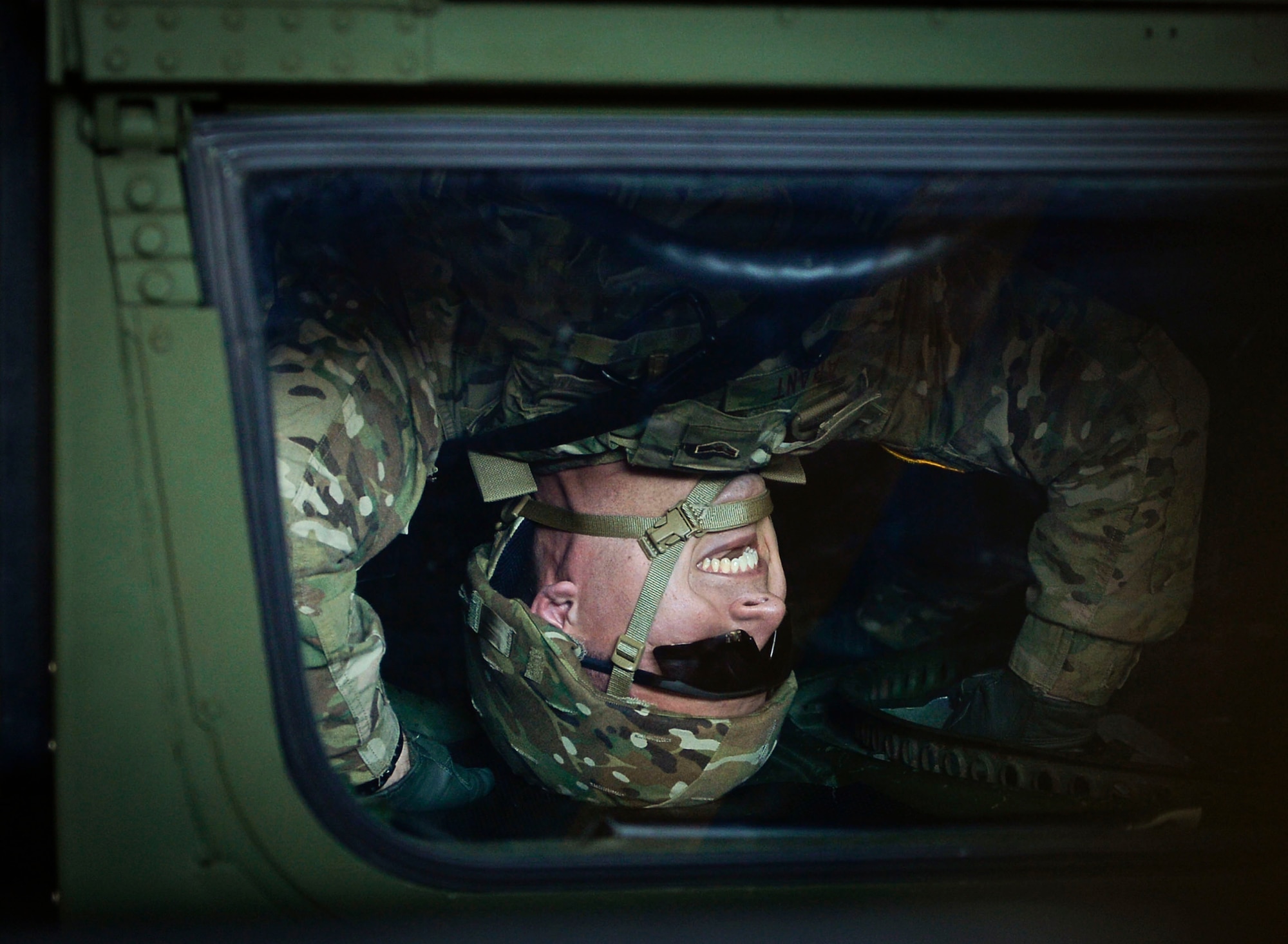 U.S. Air Force Airman 1st Class Athon Arant, 7th Weather Squadron weather apprentice, laughs as he flips upside-down in a Humvee egress assistance trainer on Lucius D. Clay Kaserne, Germany, June 14, 2017. HEAT simulators are designed to imitate a Humvee rolling over. The 7th WS regularly trains its Airmen to enhance their capabilities of working with the U.S. Army. (U.S. Air Force photo by Airman 1st Class Joshua Magbanua)