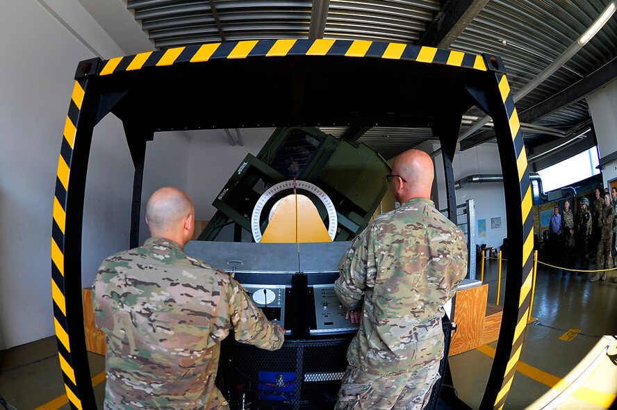 U.S. Air Force Master Sgt. Steven Hollatz, 7th Weather Squadron non-commissioned officer in charge of education and training, left, and Master Sgt. Richard Koch, 7th WS NCO in charge of readiness, operate a Humvee egress assistance trainer on Lucius D. Clay Kaserne, Germany, June 14, 2017. A HEAT machine is designed to simulate a Humvee rolling over. The 7th WS trains its Airmen in various common Soldier tasks in order to ensure their capability to cooperate with the U.S. Army. (U.S. Air Force photo by Airman 1st Class Joshua Magbanua)