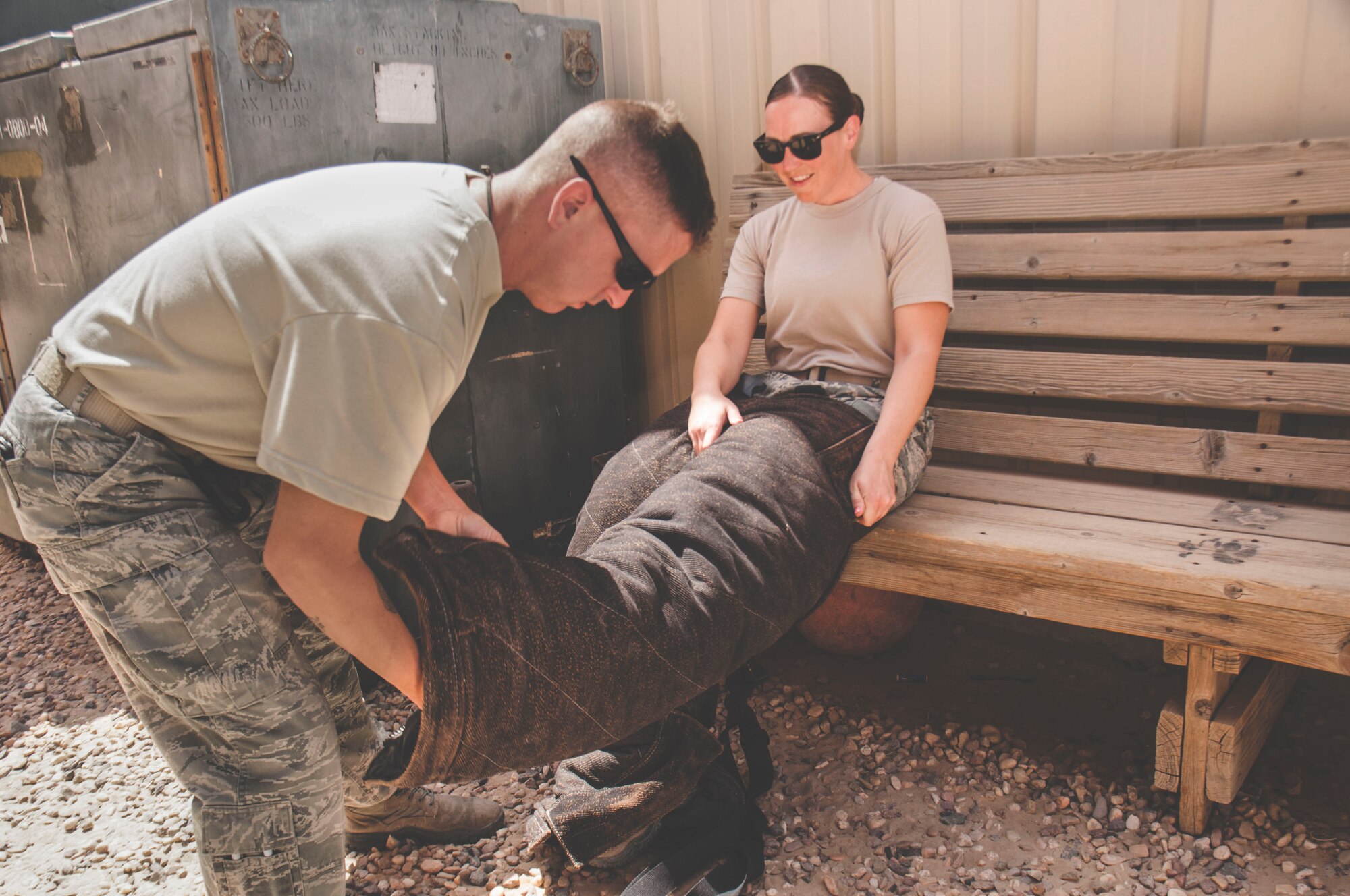 Tech. Sgt. Matthew Byrnes helps Staff Sgt. Jessica Moore into a bite suit during a mental health unit familiarization visit at an undisclosed location in southwest Asia, June 13, 2017. Moore frequently visits units that are likely to respond to trauma incidents. (U.S. Air Force Photo/Master Sgt. Eric M. Sharman)