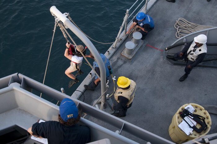 Ensign Maris Riley, a search-and-rescue swimmer assigned to USS Gladiator (MCM 11), is lowered into the water during a man-overboard drill conducted in the Arabian Gulf. Gladiator, one of four MCM ships forward deployed to Bahrain and attached to U.S. Naval Forces Central Command's Task Force 52, is a mine sweeper/hunter-killer capable of finding, classifying and destroying mines preserve the freedom of navigation and the free flow of commerce in the U.S. 5th Fleet area of operations. 