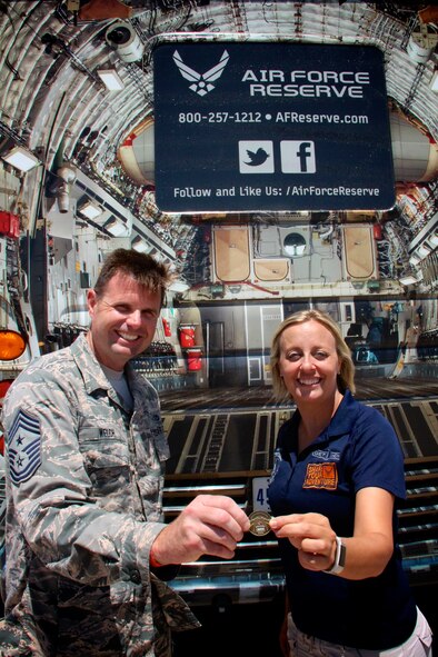 Command Chief Master Sgt. Chad Welch congratulates recruiter Tech Sgt. Sara Seibel, with a special wing coin as she reached her yearly enlistment goal early on June 9, 2017, at the Scott Air Force Base, Illinois.  This occurred during the recent air show as Lt. Col. Stan Paregien signed off on the final paperwork for her newest recruit.  She and other recruiters were on hand with public affairs, operations, and aeromedical personnel throughout the event, which included ceremonies on the flightily with the Thunderbirds. 932nd Airlift Wing members also told their particular stories about their unique jobs to the general public at the Scott Air Show. (U.S. Air Force photo by Lt. Col. Stan Paregien)