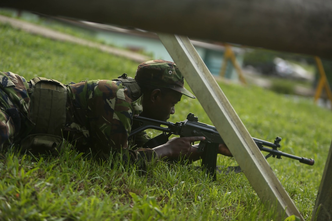 A soldier with Trinidad and Tobago Infantry Regiment, Trinidad and Tobago Defence Force, takes cover before raiding his objective during Exercise Tradewinds 2017 Phase II in Chaguaramas, Trinidad and Tobago, June 13. Tradewinds, an annual U.S. Southern Command-sponsored exercise, brings together 20 partner nations to increase Caribbean security and the combined ability to counter transnational terrorism and organize crime, and enhance humanitarian and disaster relief capabilities. (U.S. Marine Corps photo by Sgt. Olivia McDonald)