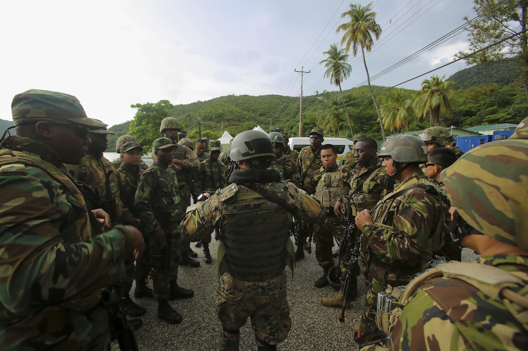 Service members from Belize, Jamaica, Trinidad and Tobago, and Mexican Marines discuss the objective before conducting a simulated raid on a hangar during Phase II of Exercise Tradewinds 2017 in Chaguaramas, Trinidad and Tobago, June 14, 2017. Tradewinds, sponsored by U.S. Southern Command, is an annual combined exercise designed to increase Caribbean security by enhancing the collective ability of the 20 participating nations to counter transnational organized crime and terrorism, and conduct humanitarian assistance and disaster relief operations. U.S. Marines are providing training and logistical support for Phase II of Tradewinds. (U.S. Marine Corps photo by Cpl. Luke Hoogendam)