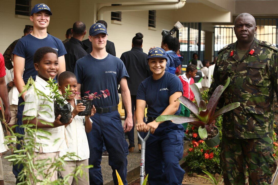 Trinidad and Tobago Defence Force Col. Roger Carter, right, the assistant chief staff officer of Headquarters, Trinidad and Tobago Defence Force, and U.S. Coast Guardsmen pose for a photo with students while at Carenage Boy Government Primary School as part of a community relations event during Phase II of Exercise Tradewinds 2017 in Chaguaramas, Trinidad and Tobago, June 16, 2017. Tradewinds, sponsored by U.S. Southern Command, brings together security forces and regional civilian agencies from 20 participating countries to strengthen relationships, build partner nation capacity and conduct subject matter expert exchanges in security-related operations. U.S. Marines are providing providing training and logistical support for Phase II of the exercise. (U.S. Marine Corps photo by Sgt. Olivia McDonald)
