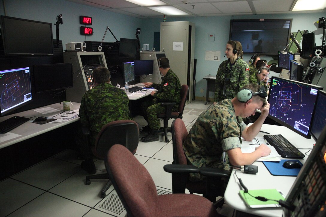 Lance Corporal Ian Roberts (right foreground), a United States Marine Corps tactical air defense controller, works alongside Royal Canadian Air Force 42 Radar Squadron air battle managers at 4 Wing Cold Lake, Alberta, on May 31, 2017, during Exercise Maple Flag 50.