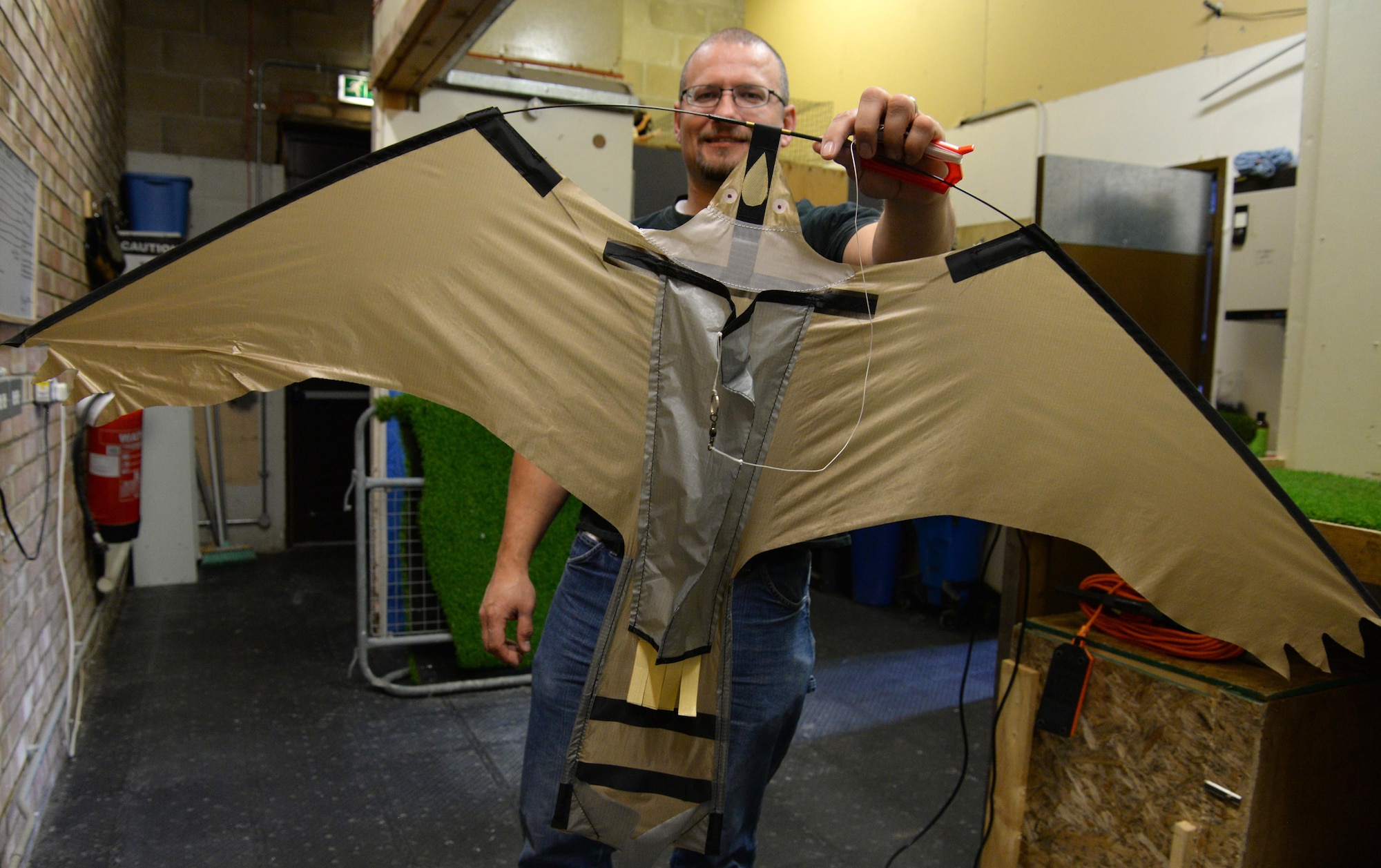 Michael Grant, Loomacres Wildlife Management Cell senior wildlife biologist, displays a bird kite on RAF Mildenhall, England June 12, 2017. Grant, the lead supervisor of the Bird Air Strike Hazard Program, used his specialized knowledge and experience with wildlife on the flightline to help develop procedural guidelines for the use of the bird kites. (U.S. Air Force photo by Senior Airman Justine Rho)  