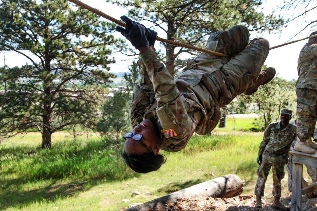 Missouri Army National Guard Pfc. Synetta Stevenson climbs across a rope obstacle during the Leadership Reaction Course in support of exercise Golden Coyote, Rapid City, S.D., June 13, 2017. Stevenson is assigned to the 1138th Transportation Company. Army photo by Spc. Jeffery Harris
