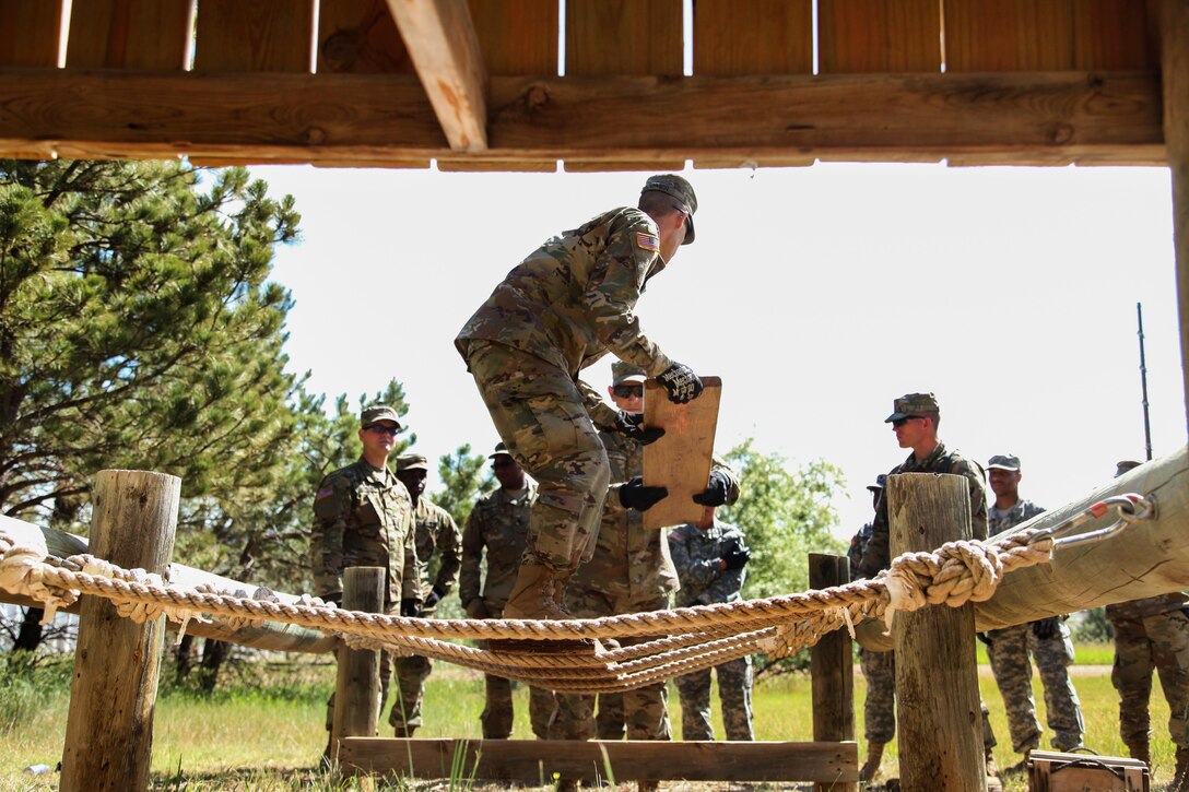 Missouri Army National Guard Spc. Christopher Bodimer places a board over an obstacle during the Leadership Reaction Course in support of exercise Golden Coyote, Rapid City, S.D., June 13, 2017. Bodimer is assigned to the 1138th Transportation Company. Army photo by Spc. Jeffery Harris