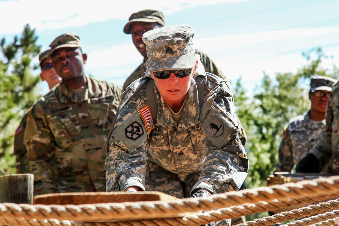 Army Sgt. Deanna Ross attempts to cross over a rope obstacle during the Leadership Reaction Course in support of exercise Golden Coyote, Rapid City, S.D., June 13, 2017. Ross is assigned to the 1138th Transportation Company from the Missouri Army National Guard. Army photo by Spc. Jeffery Harris