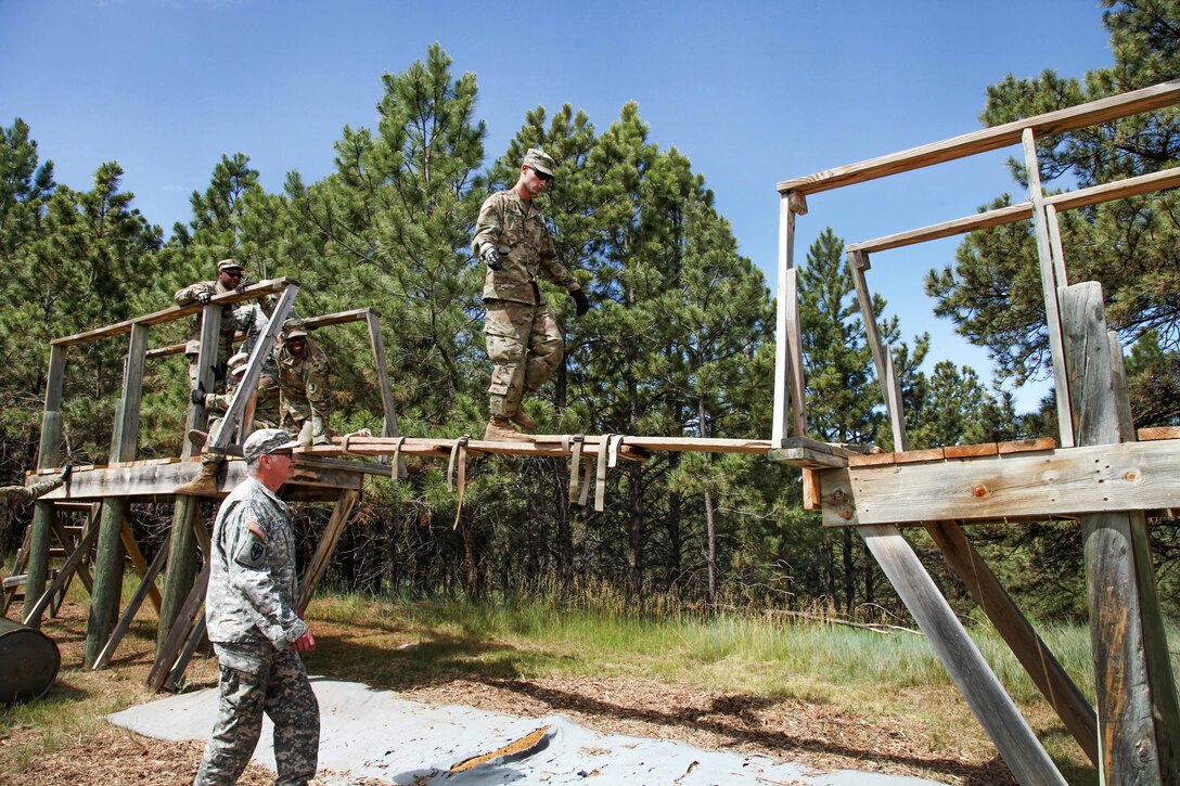 Army Spc. Christopher Bodimer walks across a makeshift bridge during the Leadership Reaction Course in support of exercise Golden Coyote, Rapid City, S.D., June 13, 2017. Bodimer is assigned to the 1138th Transportation Company, Missouri Army National Guard. Army photo by Spc. Jeffery Harris