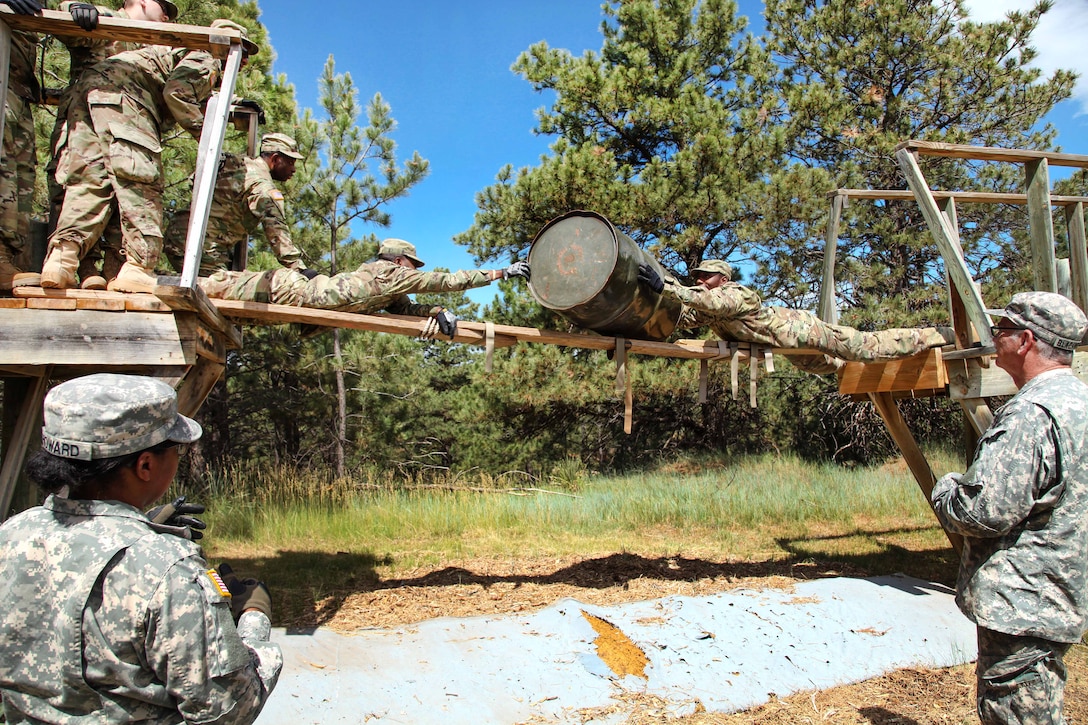 Missouri Army National Guardsmen roll a barrel to the opposite side of the obstacle during the Leadership Reaction Course in support of exercise Golden Coyote, Rapid City, S.D., June 13, 2017. Army photo by Spc. Jeffery Harris