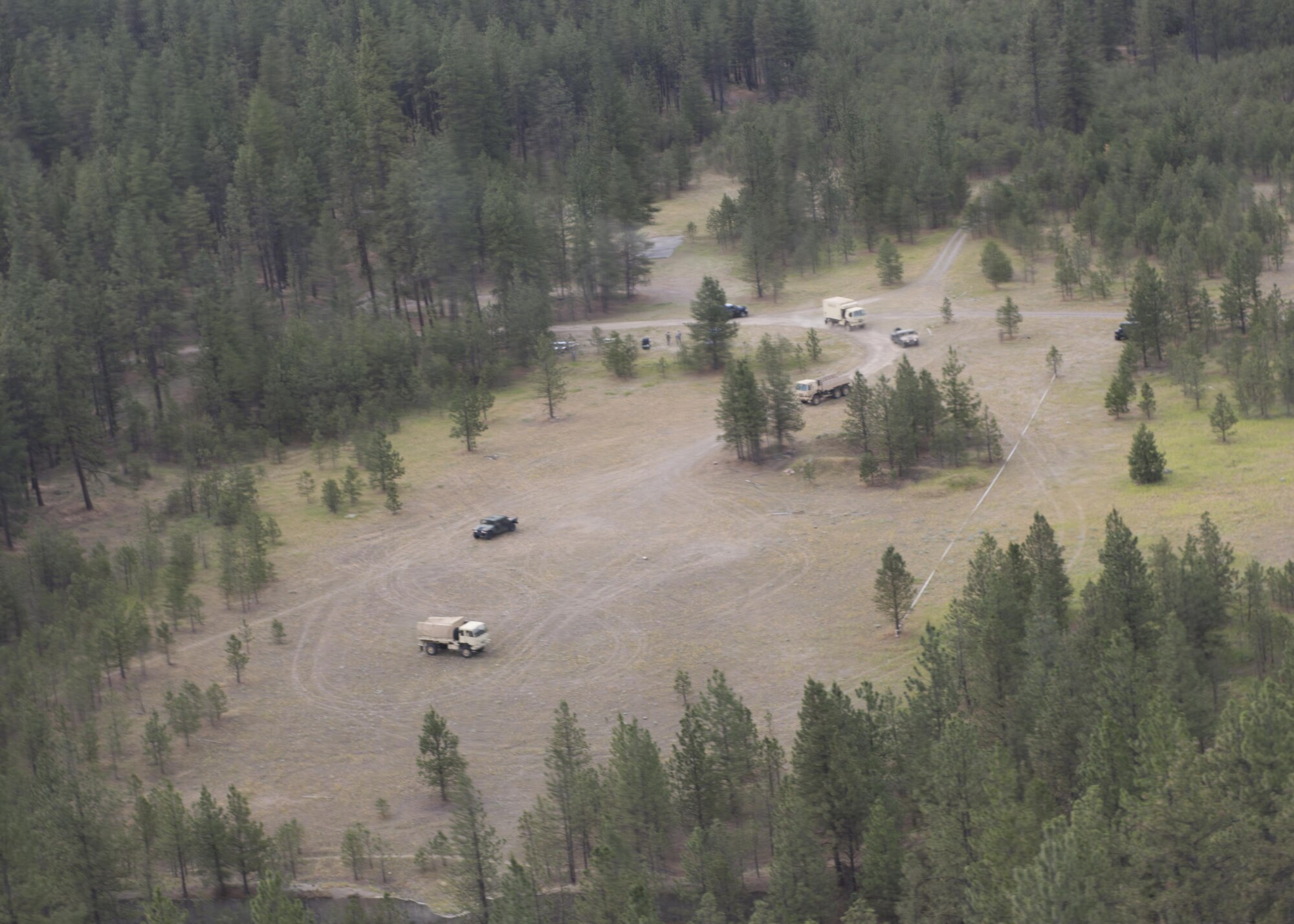 A convoy from the Washington National Guard, C Company, 1st Battalion, 112th Airborne Regiment converge on a disabled truck with the assistance of a Lakota helicopter June 14, 2017, north of Fairchild Air Force Base, Washington. NG ground crews use Lakota helicopters to provide a "eye in the sky" for locating and directing Soldiers to target sites.