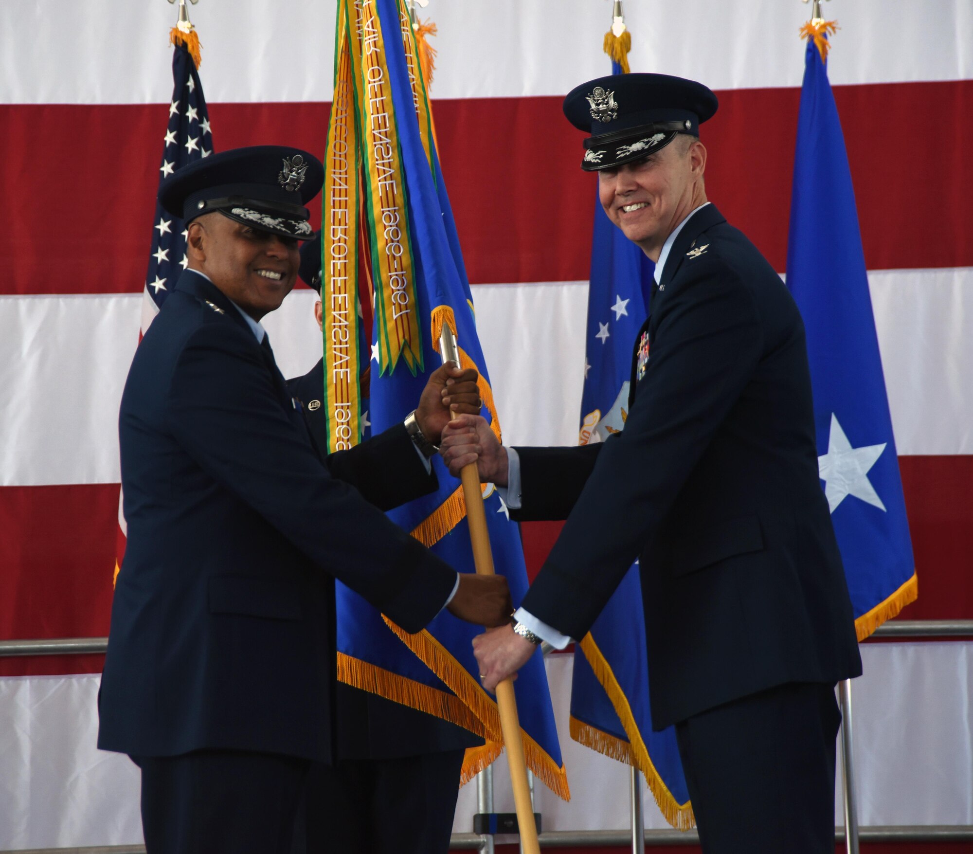 Maj. Gen. Anthony Cotton, 20th Air Force commander, passes the guidon to Col. Richard W. Gibbs, 377th Air Base Wing commander during a change of command ceremony at Kirtland Air Force Base, New Mexico, June 16. Gibbs takes command from Col Eric H. Froehlich, who commanded the host unit of Kirtland for two years. (U.S. Air Force photo by Senior Airman Chandler Baker)