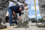 Students watch as an instructor adds cement mix to a hole before finishing a new patch of cement during a Pavements Maintenance, Inspection and Repair course, June 15, 2017, at Moody Air Force Base, Ga. Every year, training managers at the major command level across the Air Force pick multiple bases across the Air Force to host the course, and this year Moody hosted one from June 5-16. (U.S. Air Force photo by Senior Airman Janiqua P. Robinson)