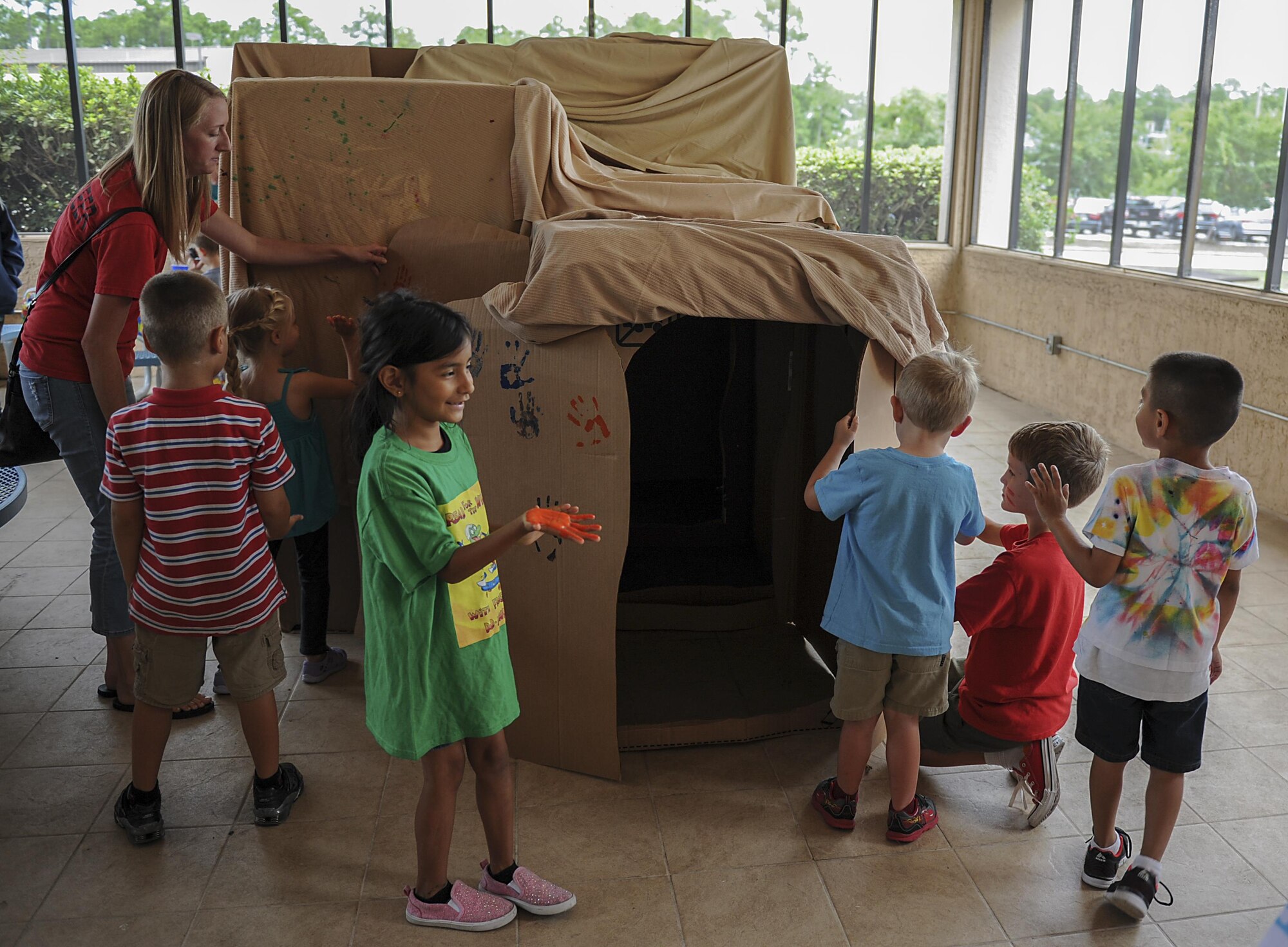 Military children mark their handprints on a “cave” during the Summer Reading Program at the Landing Zone on Hurlburt Field, Fla., June 15, 2017. The young Air Commandos were sent “back in time” to be cavemen as part of the program’s “Reading by Design” theme, exploring the history of architecture. (U.S. Air Force photo by Airman 1st Class Rachel Yates)