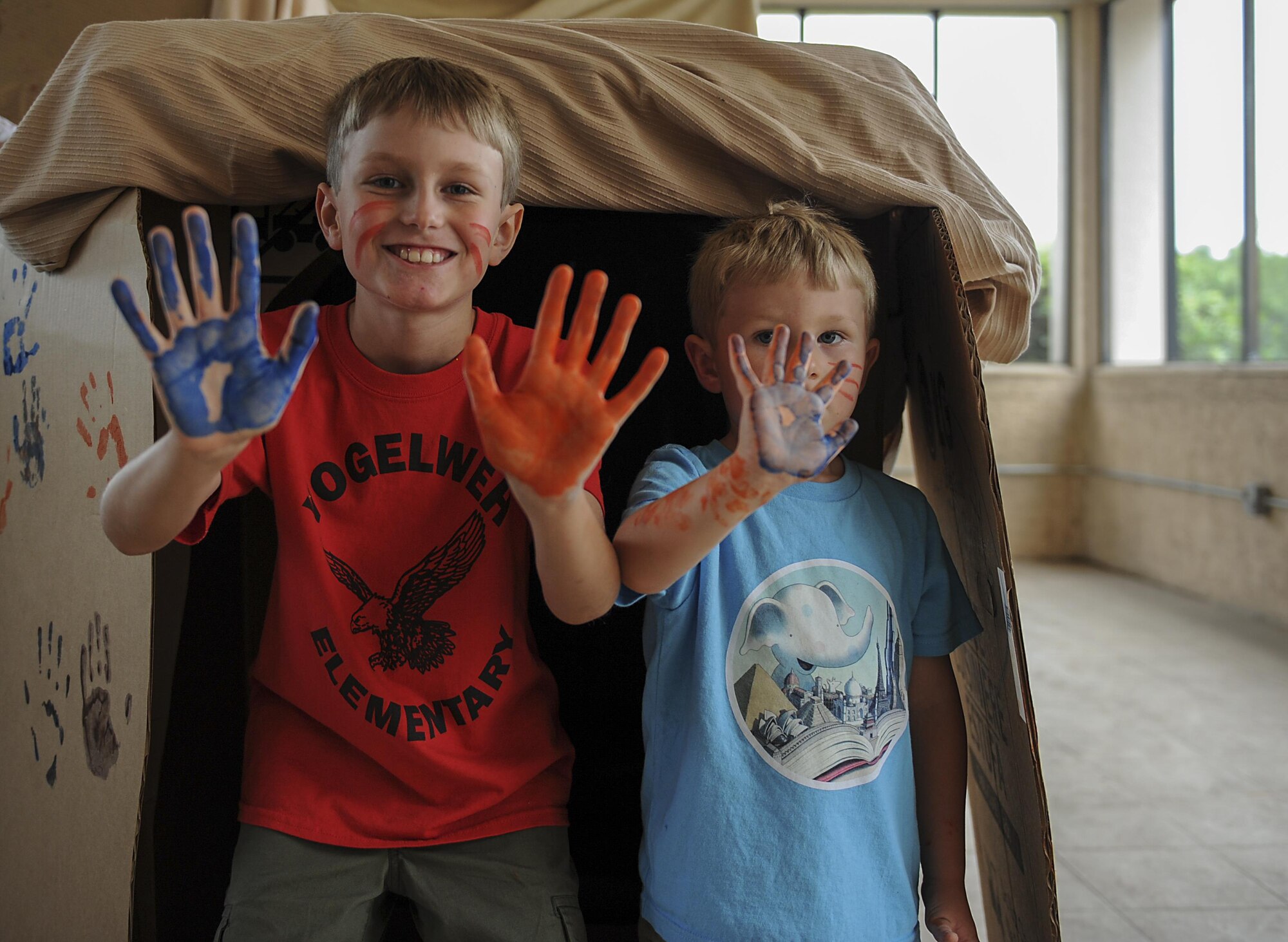 Grant, 9, and Gunnar, 4, Cumming show off their painted hands during the Summer Reading Program at the Landing Zone at Hurlburt Field, Fla., June 15, 2017. Grant and Gunnar, along with the other several dozen young Air Commandos, embarked on an imaginary dinosaur hunt and marking a “cave” with their handprints after their success. (U.S. Air Force photo by Airman 1st Class Rachel Yates)