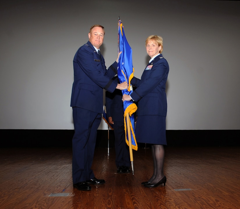 Maj. Gen. Darryl Burke (left), Air Force District of Washington commander, receives the 79th Medical Wing guidon from Col. Sharon Bannister, former 79th Medical Wing commander, during an in-activation ceremony June 16, 2017 at Joint Base Andrews, Md. Bannister had led the wing since assuming command 2015 and its approximately 1,500 Air Force health care professionals operating in eight locations and providing Air Force medical forces for expeditionary deployment, homeland defense operations and operations worldwide. (Photo by Staff Sgt. Joe Yanik)