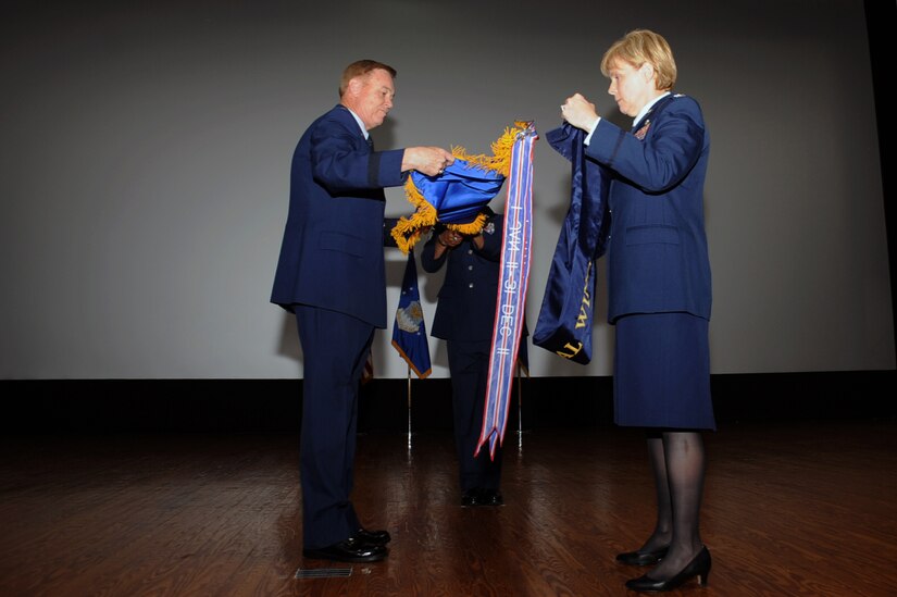Maj. Gen. Darryl Burke (left), Air Force District of Washington commander, and Col. Sharon Bannister, former 79th Medical Wing commander, furl and case the wing's guidon during an in-activation ceremony June 16, 2017 at Joint Base Andrews, Md. The guidon will be stored in the National Museum of the U.S. Air Force, Dayton, Ohio, in the event the wing is re-activated. (Photo by Staff Sgt. Joe Yanik)