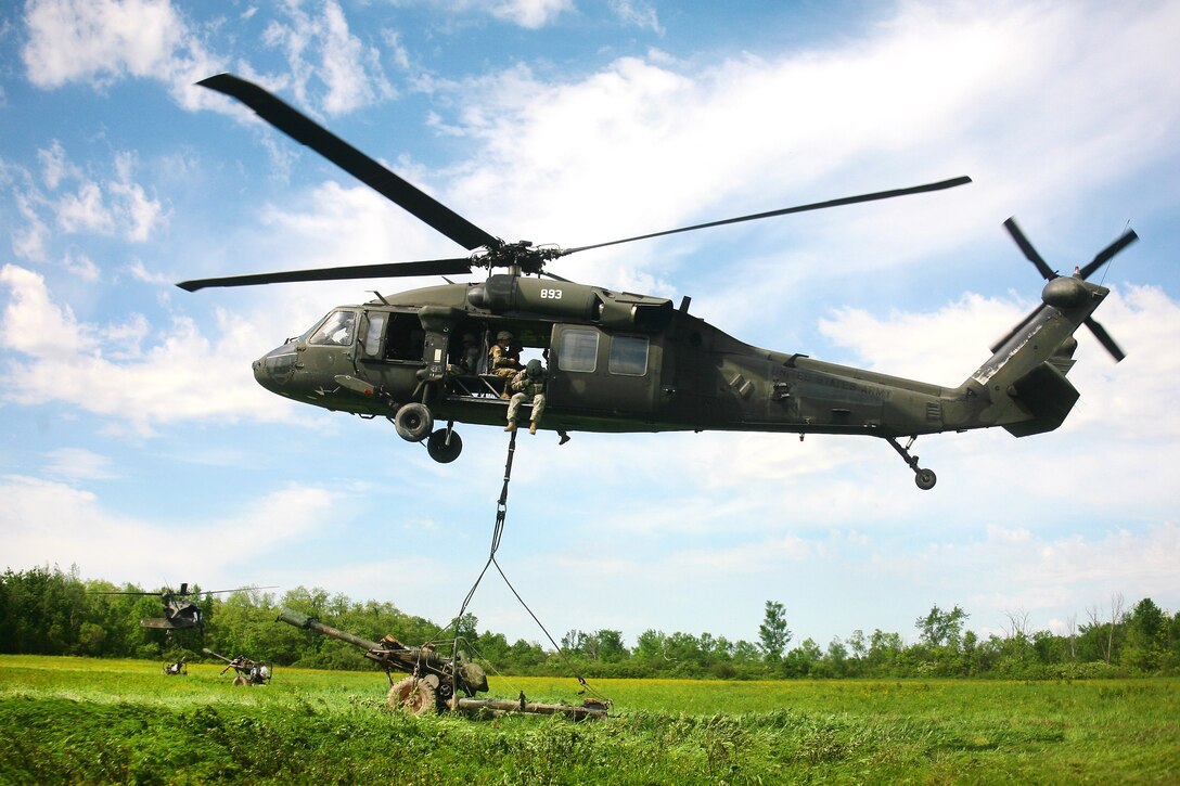 A New York Army National Guard UH-60 Black Hawk helicopter transports an M119A2 105mm howitzer during an air assault artillery raid at Fort Drum, N.Y., June 9, 2017. The crew is assigned to the 3rd Battalion, 142nd Aviation Regiment. Army photo by Sgt. Alexander Rector
