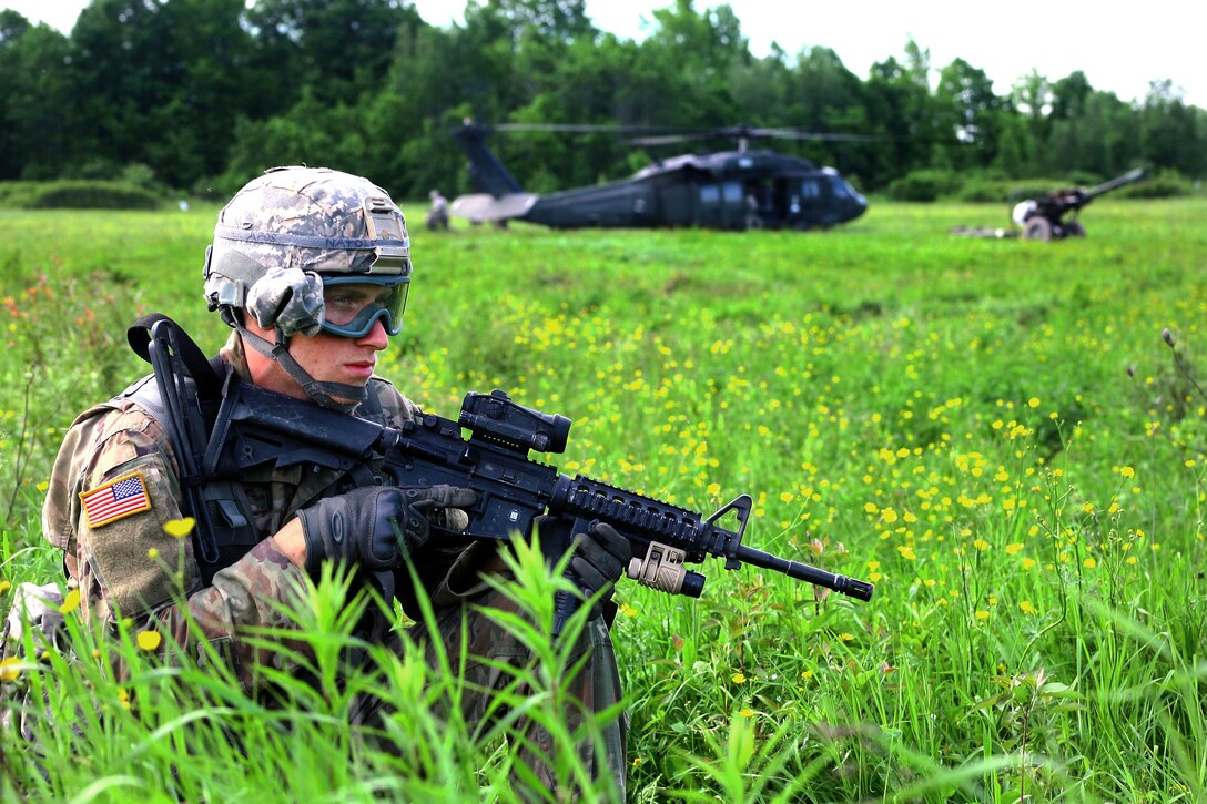 Army Pfc. Michael Natole provides security stands during an air assault artillery raid at Fort Drum, N.Y., June 9, 2017. Natole is a cannon crewmember assigned to Alpha Battery, 1st Battalion, 258th Artillery Regiment, 27th Infantry Brigade Combat Team of the New York Army National Guard. Army National Guard photo by Sgt. Alexander Rector