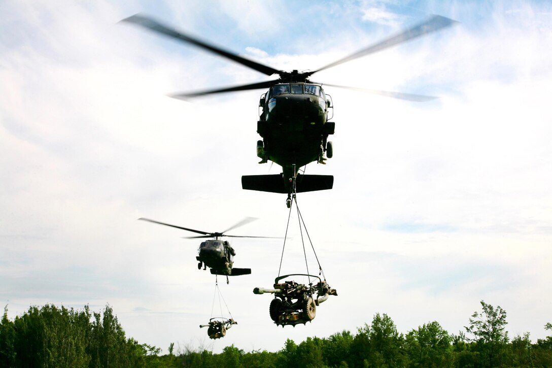 New York Army National Guard UH-60 Black Hawk helicopters transport M119A2 105mm howitzers to a landing zone during an air assault artillery raid at Fort Drum, N.Y., June 9, 2017. Army photo by Sgt. Alexander Rector
