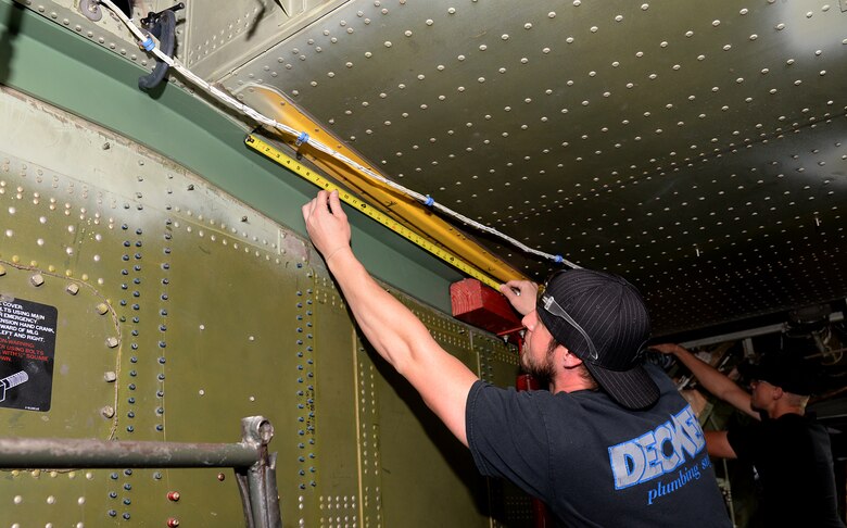 572nd Aircraft Maintenance Squadron Sheet Metal Mechanic Quinn Ganz measures a new center wing attach angle for proper alignment on a C-130 aircraft at Hill Air Force Base, Utah. This part is used to connect the wings of the aircraft to the landing gear and was also replaced on Fat Albert during its maintenance overhaul at the Ogden Air Logistics Complex. (U.S. Air Force Photo by Alex R. Lloyd)