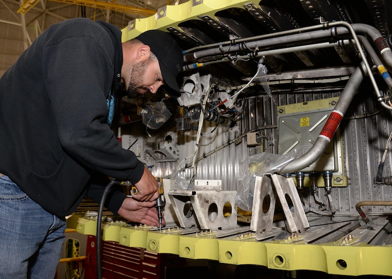 572nd Aircraft Maintenance Squadron production supervisor Jason Smith tightens the bolts on a C-130 Hercules’ lower wing rainbow fitting at Hill Air Force Base, Utah. The fittings are used to mate the center and outer wing sections on a C-130 and were the damaged parts first noticed under inspection on Fat Albert. (U.S. Air Force Photo by Alex R. Lloyd)
