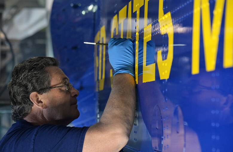 576th Aircraft Maintenance Squadron Painter Terrel Fry uses a steady hand to apply touchup paint to the side of Fat Albert on May 31 at Hill Air Force Base, Utah. Paying close attention to detail helps showcase the pride in workmanship for the paint crew.  (U.S. Air Force Photo by Alex R. Lloyd)