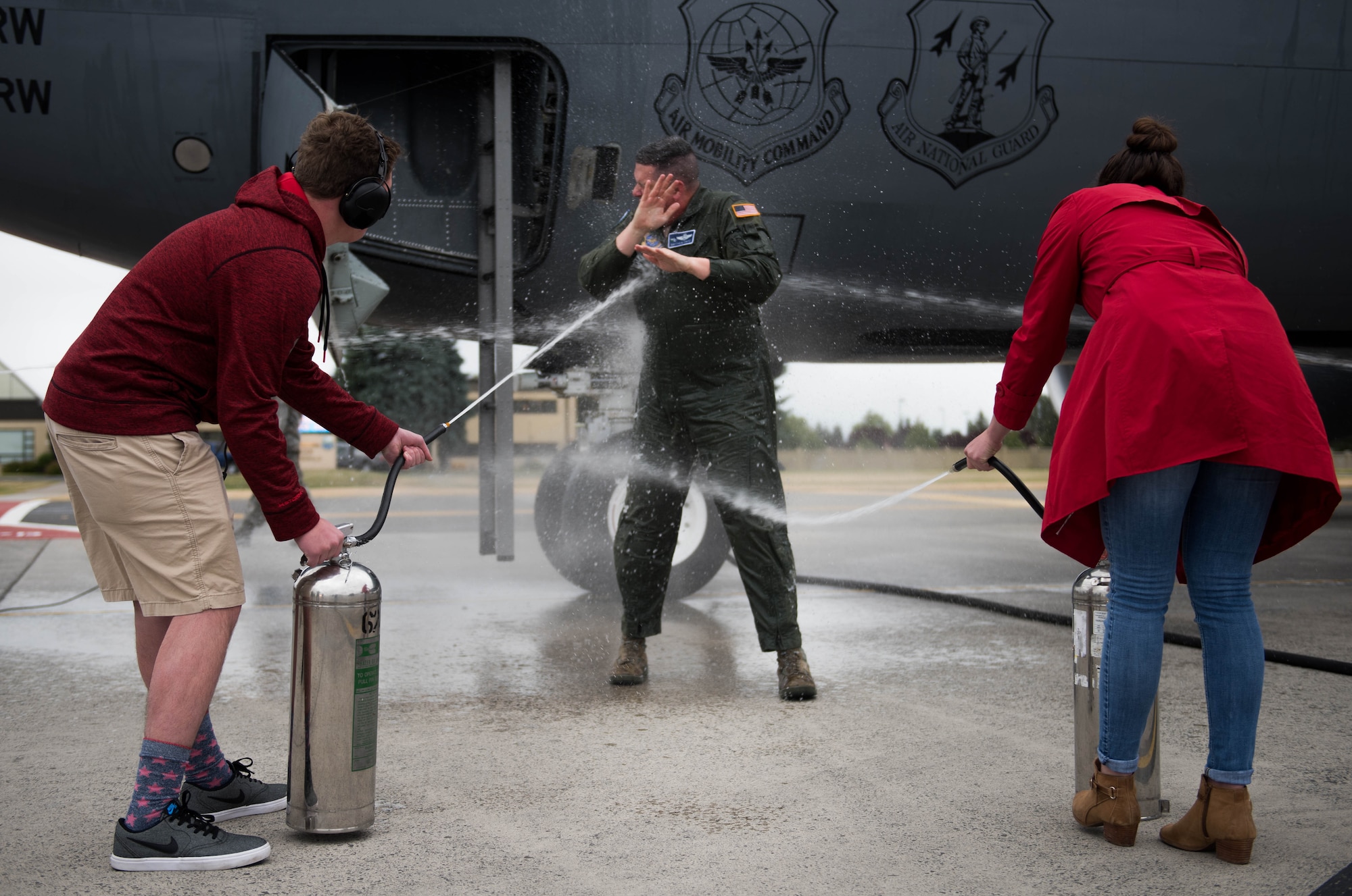 Col. Matthew Fritz, 92nd Air Refueling Wing vice commander, is sprayed with water by his children, Matthew and Taylor, after returning from his final flight as vice commander June 15, 2017, at Fairchild Air Force Base, Washington. Fritz was joined by his family and various members of Team Fairchild to celebrate. (U.S. Air Force photo/Senior Airman Sean Campbell)