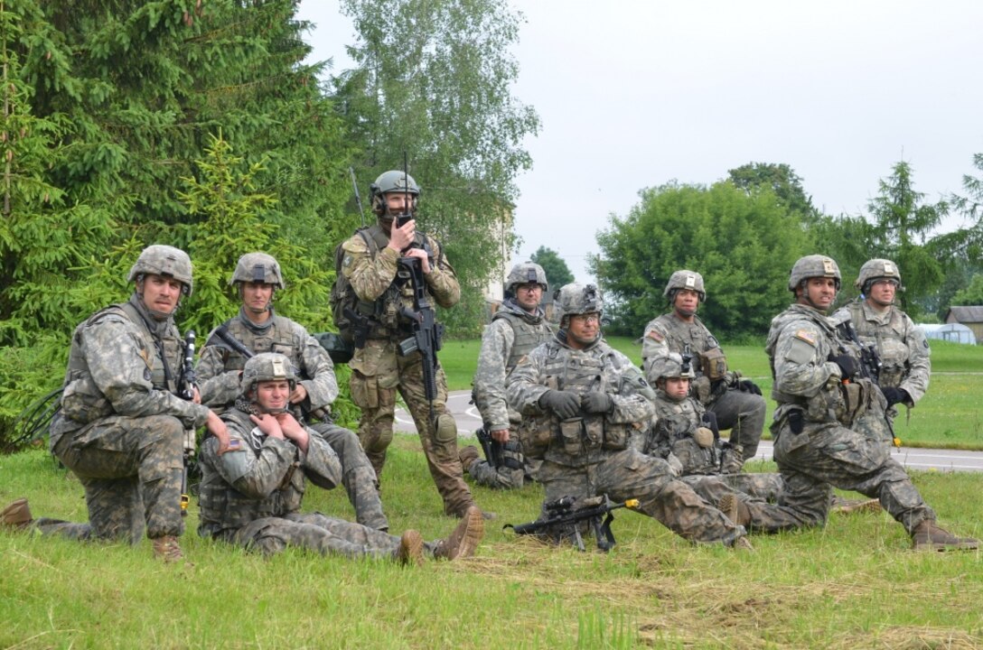A combined forces squad featuring members of the Minnesota Army National Guard's 1st Armored Brigade Combat Team, 34th Infantry Division, British Royal Marines and Polish soldiers wait at a collection point for the medical evacuation of simulated casualties during Exercise Saber Strike 17 near Sventezeris, Lithuania, June 18, 2017. Army photo by Sgt. Shiloh Capers