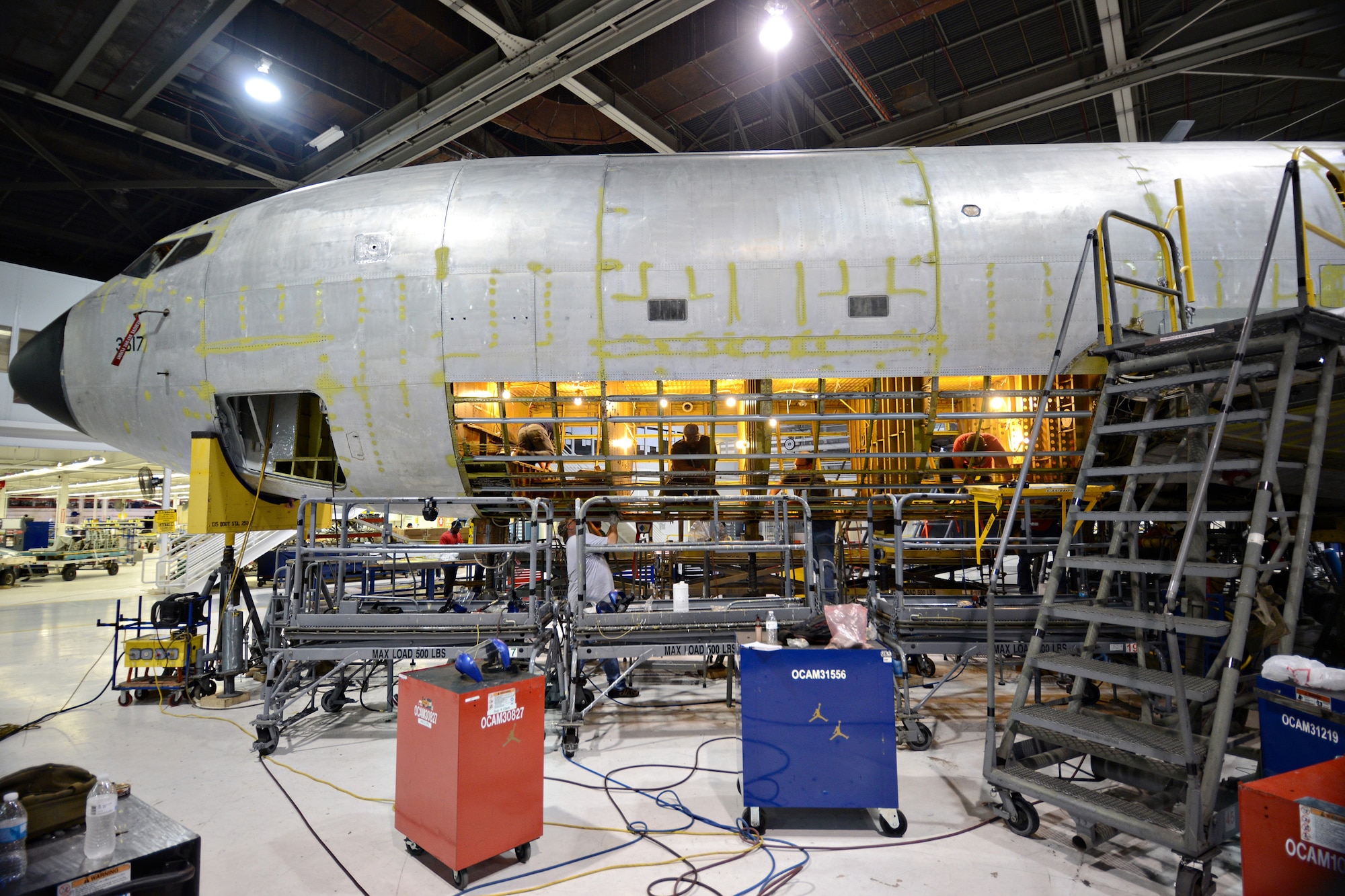 Sheet metal mechanics with the 76th Aircraft Maintenance Group working on the KC-135 Programmed Depot Maintenance line perform a double belly skin removal. Although a single belly removal is normally called for in PDM, double belly removals are not unusual and are required when both sides of the aircraft have corrosion and other defects. (Air Force photo by Kelly White)