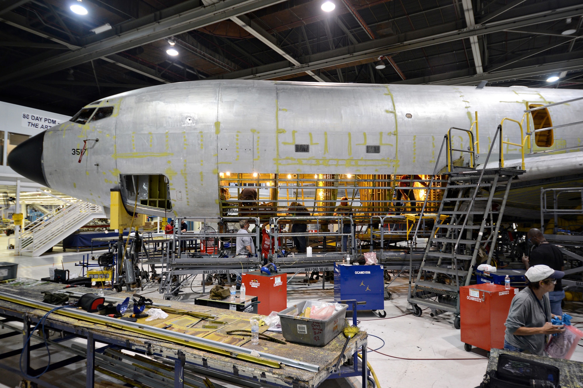 Sheet metal mechanics with the 76th Aircraft Maintenance Group working on the KC-135 Programmed Depot Maintenance line perform a double belly skin removal. Although a single belly removal is normally called for in PDM, double belly removals are not unusual and are required when both sides of the aircraft have corrosion and other defects. (Air Force photo by Kelly White)