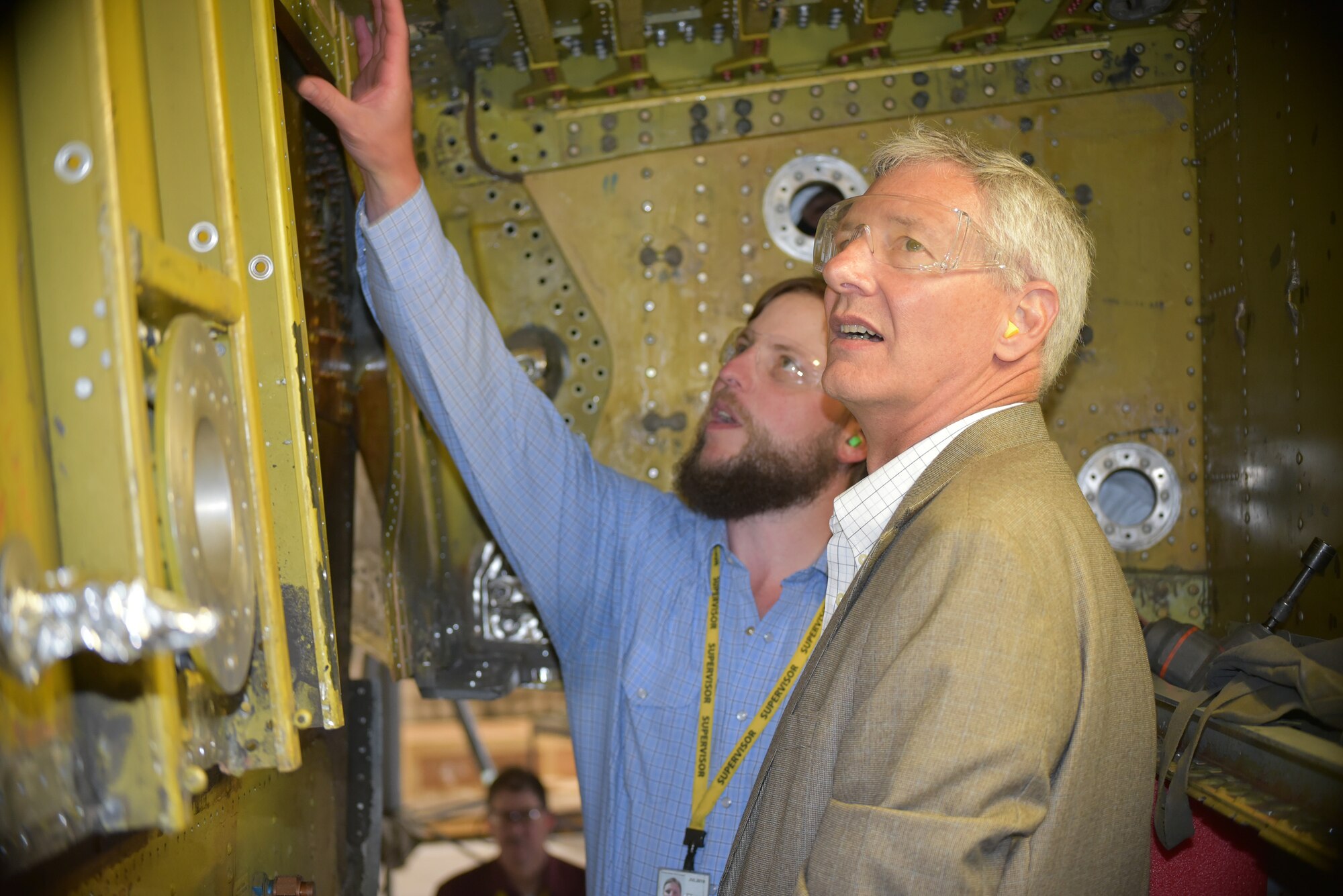 Daron Bender, a sheet metal chief with the 564th Aircraft Maintenance Squadron, left, provides Wayne Schatz Jr., associate deputy chief of staff for operations, headquarters, United States Air Force, with an overview of the aft wing terminal fitting and center wing spar replacement procedures being performed on the KC-135 “Stratotanker” during his visit to Tinker Air Force Base May 22-23. During his two-day visit, Schatz was able to discuss and receive updates on Air Force Sustainment Center logistics and sustainment, to include updates on the E-3 “Sentry” Airborne Warning and Control System aircraft, as well as impacts to fleet health and readiness as pilot production increases on Air Force weapon systems. (Air Force photo by Darren D. Heusel)