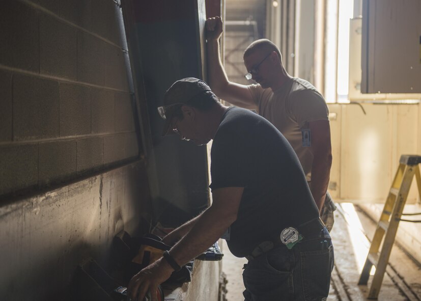 From left to right, Sam Lucas and U.S Air Force Staff. Sgt. Coleman Ballard 7th Civil Engineer structures craftsman, repair and replace a hangar door motor at Dyess Air Force Base, Texas, June 7, 2017. Structures Airmen are responsible for fixing and maintaining a majority of interior structures, such as: hangar doors, ceiling tiles and walls. (U.S. Air Force photo by Airman 1st Class Katherine Miller)