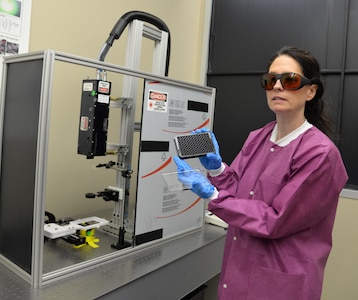 Dr. Nancy Millenbaugh, research chemist and principal investigator for the Craniofacial Health and Restorative Medicine Directorate at Naval Medical Research Unit San Antonio, holds a plate which is used for testing samples of biofilms for research into the effectiveness of nanoparticle targeted laser therapy in improving the treatment of multi-drug resistant wound infections, especially for servicemembers with maxillofacial injuries from combat. Researchers are hoping to develop a nanoparticle laser therapy that can breakdown biofilms, which contain a protecting coating produced by bacteria that make infections in the wound resistant to antibiotic treatment.