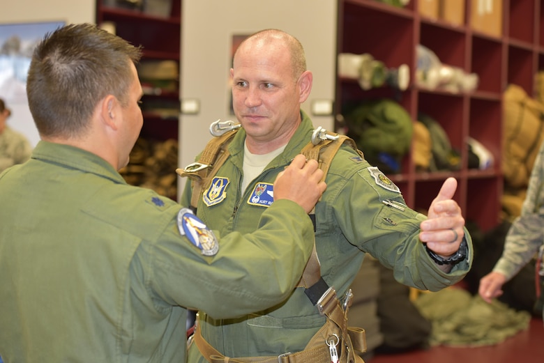 Lt. Col. Ryan Montanez, (left) combat rescue officer and 308th Rescue Squadron commander, outfits 920th Rescue Wing, Commander Kurt A. Matthews, Patrick Air Force Base, Florida, with skydiving gear. The commander, along with the 45th Space Wing commander, Brig. Gen. Wayne R. Monteith, co-located at PAFB, skydived to demonstrate their commitment to mutual-support and shared resources in an unforgettable way June 8, 2017. (U.S. Air Force photo / Senior Airman Brandon Kalloo Sanes)