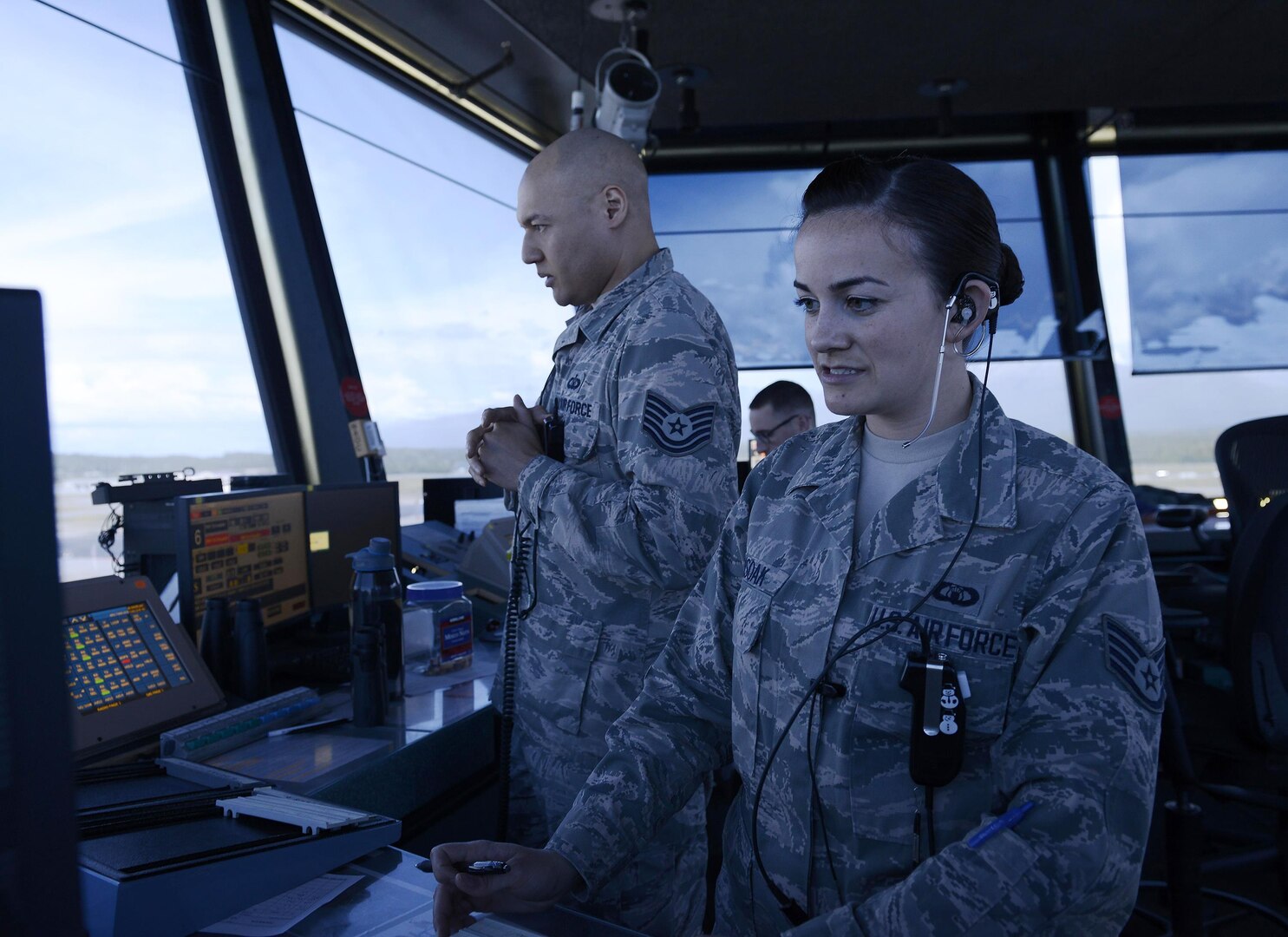U.S. Air Force Staff Sgt. Amanda Ahsoak, air traffic control journeyman, and Tech. Sgt. Jason McLean, air traffic control tower watch supervisor, give direction to an inbound aircraft, Joint Base Elmendorf-Richardson, Alaska, June 15, 2017. ATC Airmen are responsible for the safety and control of hundreds of military and civilian aircraft every day.
