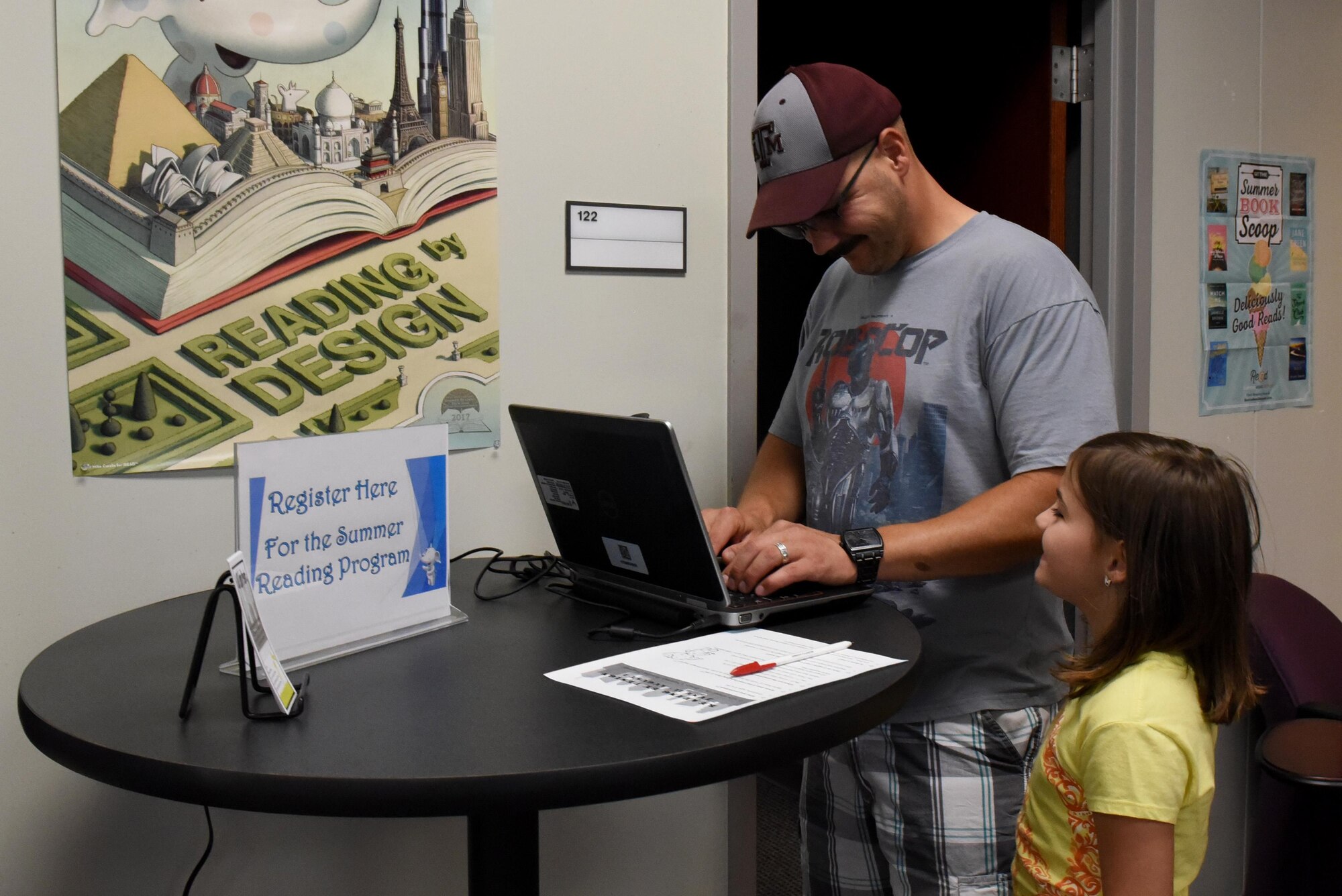 Tech. Sgt. Jarrett Harkey, 4th Equipment Maintenance Squadron aircraft structural phase lead, and his daughter, sign up for the Department of Defense Summer Reading Program, June 13, 2017, at the base library at Seymour Johnson Air Force Base, North Carolina. Participants ages birth through adulthood can register for the Summer Reading Program at the library or online at https://seymourjohnson.beanstack.org/reader365. (U.S. Air Force photo by Airman 1st Class Victoria Boyton)