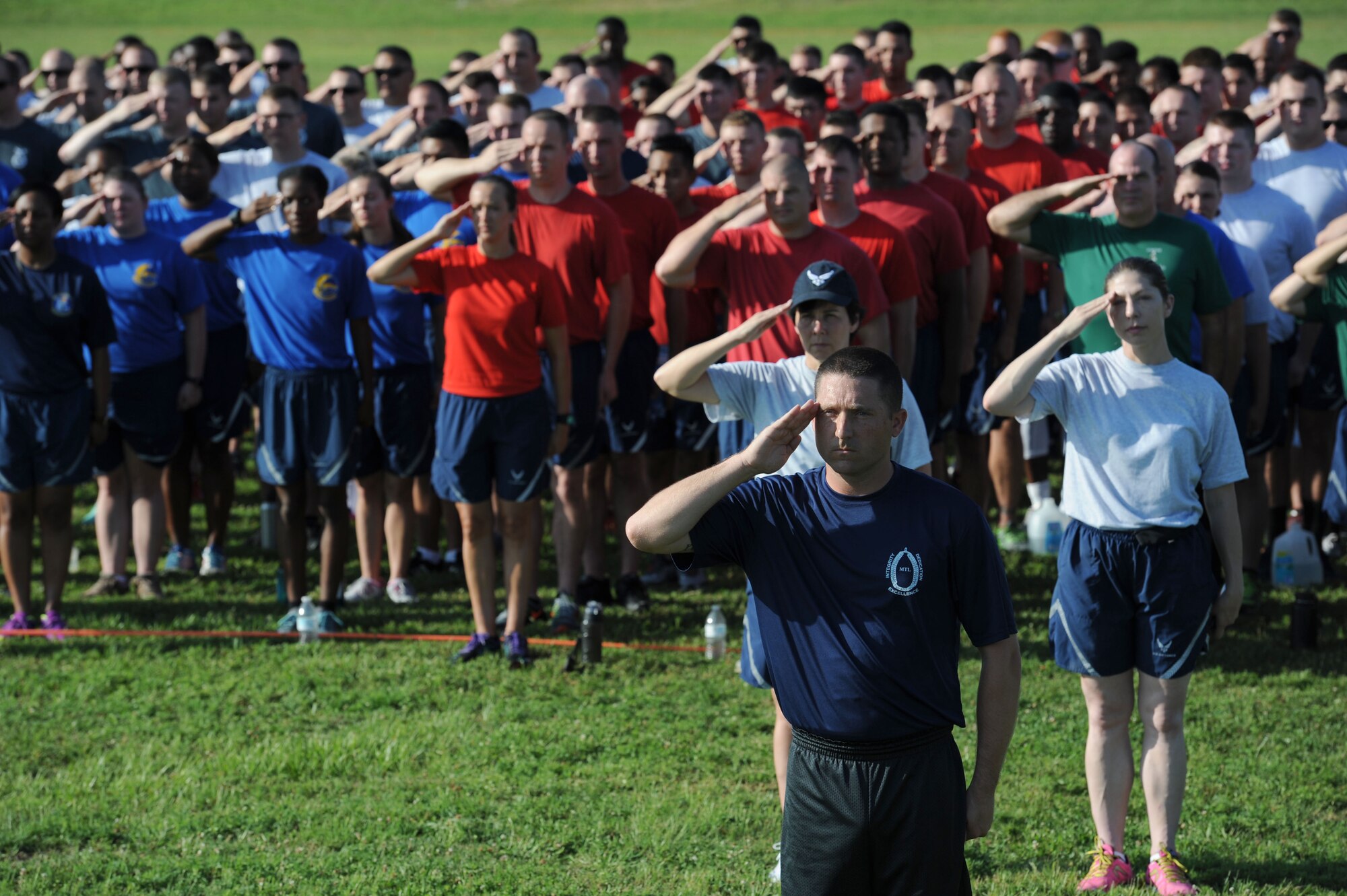 Tech. Sgt. Roger Anderson III, 81st Training Group military training leader, and Keesler personnel renders salutes during the singing of the National Anthem during field day June 15, 2017, on Keesler Air Force Base, Miss. Field day was the final event of Wingman Week, which focused on the physical pillar of Comprehensive Airman Fitness, resiliency and teambuilding initiatives across the base. (U.S. Air Force photo by Kemberly Groue)