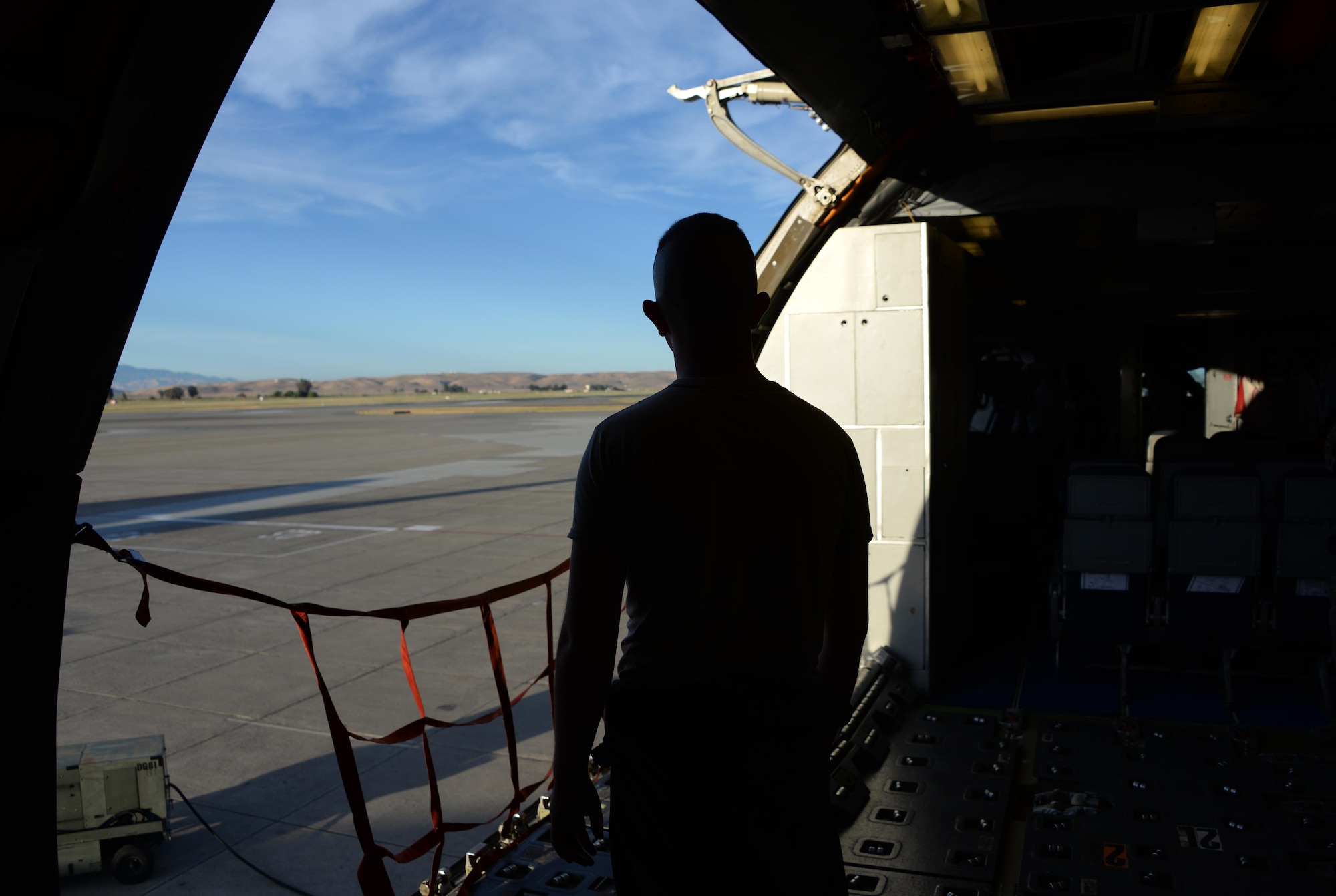 Airman 1st Class Garret Jacobs, 6th Air Refueling Squadron, waits for cargo to arrive inside a KC-10 Extender at Travis Air Force Base, Calif., June 17, 2017. Jacobs helped load more than 15,000 pounds of cargo prior to a flight to Joint Base Pearl Harbor-Hickam, Hawaii. The KC-10 is capable of transporting 170,000 pounds of cargo. (U.S. Air Force photo by Tech. Sgt. James Hodgman)